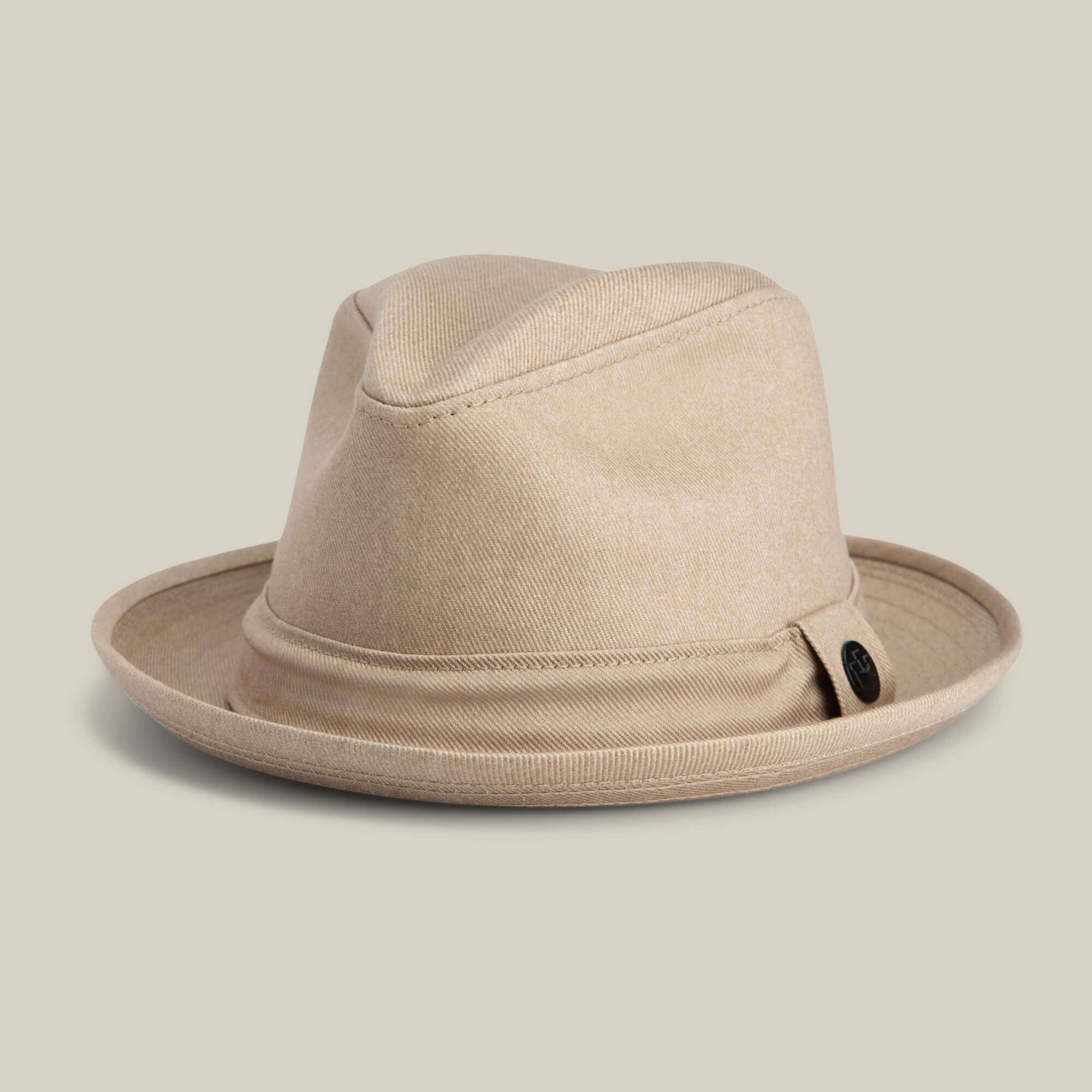 The Big Stepper by Goorin Bros. is a beige fedora with a wide brim and black button detail on the side, shown against a plain light background.