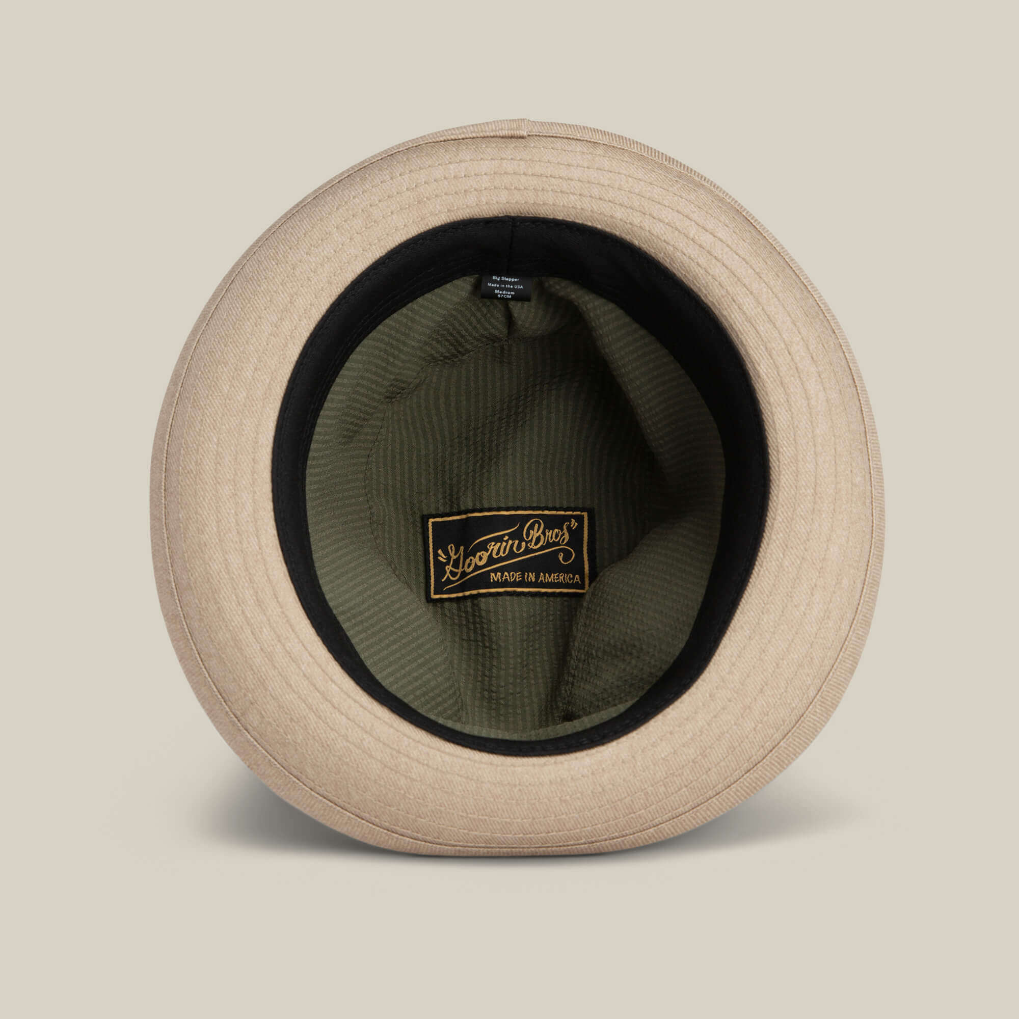 The Goorin Bros. Big Stepper is a beige statement hat shown from above with its inner lining and a black and gold "Made in America" label visible—an elegant fashion accessory for any wardrobe.