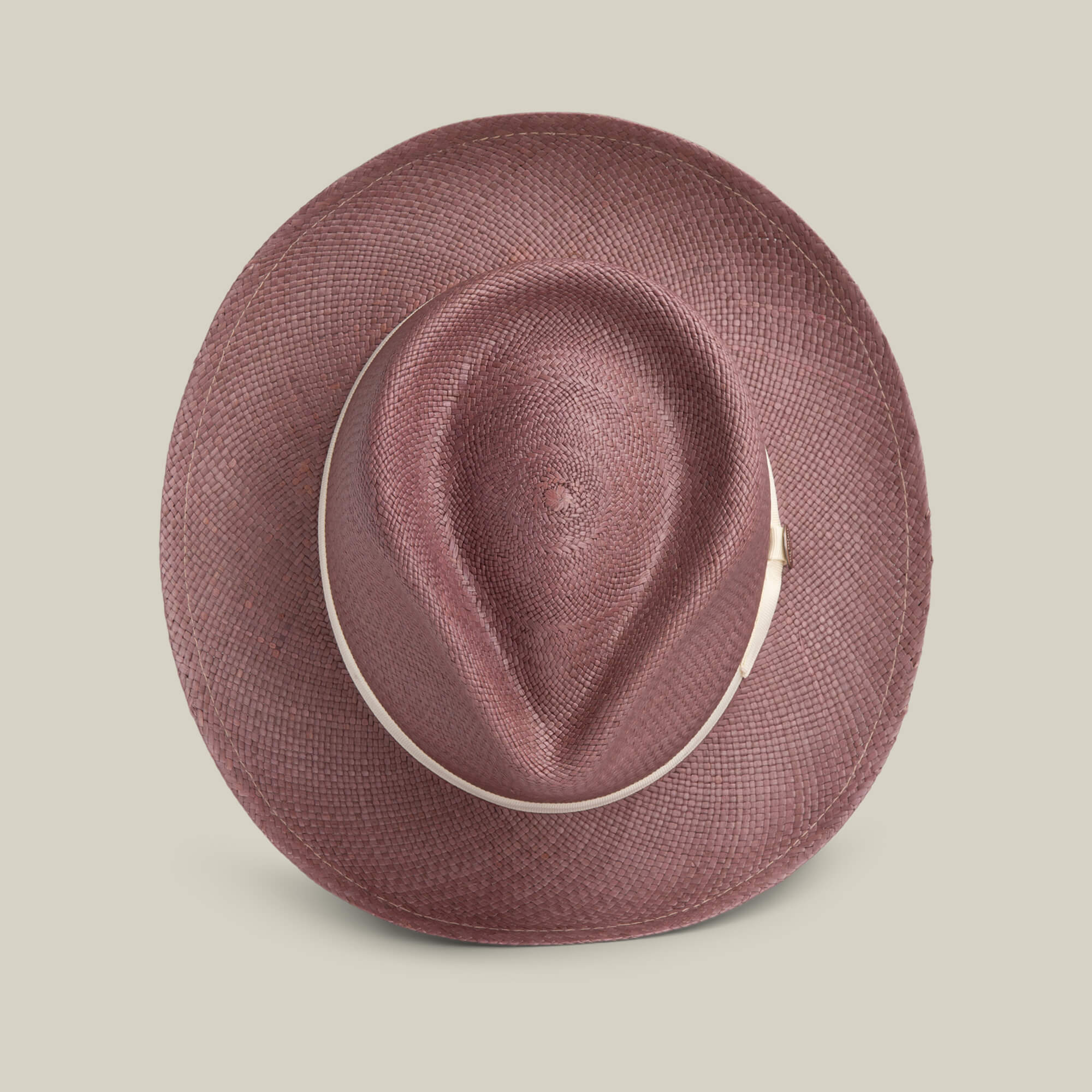 A top view of the John Sr. maroon toquilla teardrop fedora by Goorin Bros., featuring a wide brim and light band, set on a beige background—an elegant 50 UPF sun-protective choice.