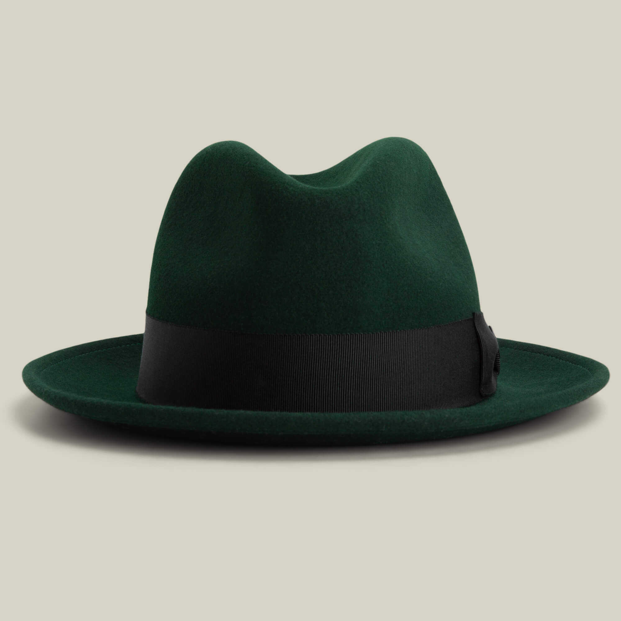 Dean the Butcher by Goorin Bros.: an American-made dark green fedora with a black ribbon band, shown on a plain beige background.