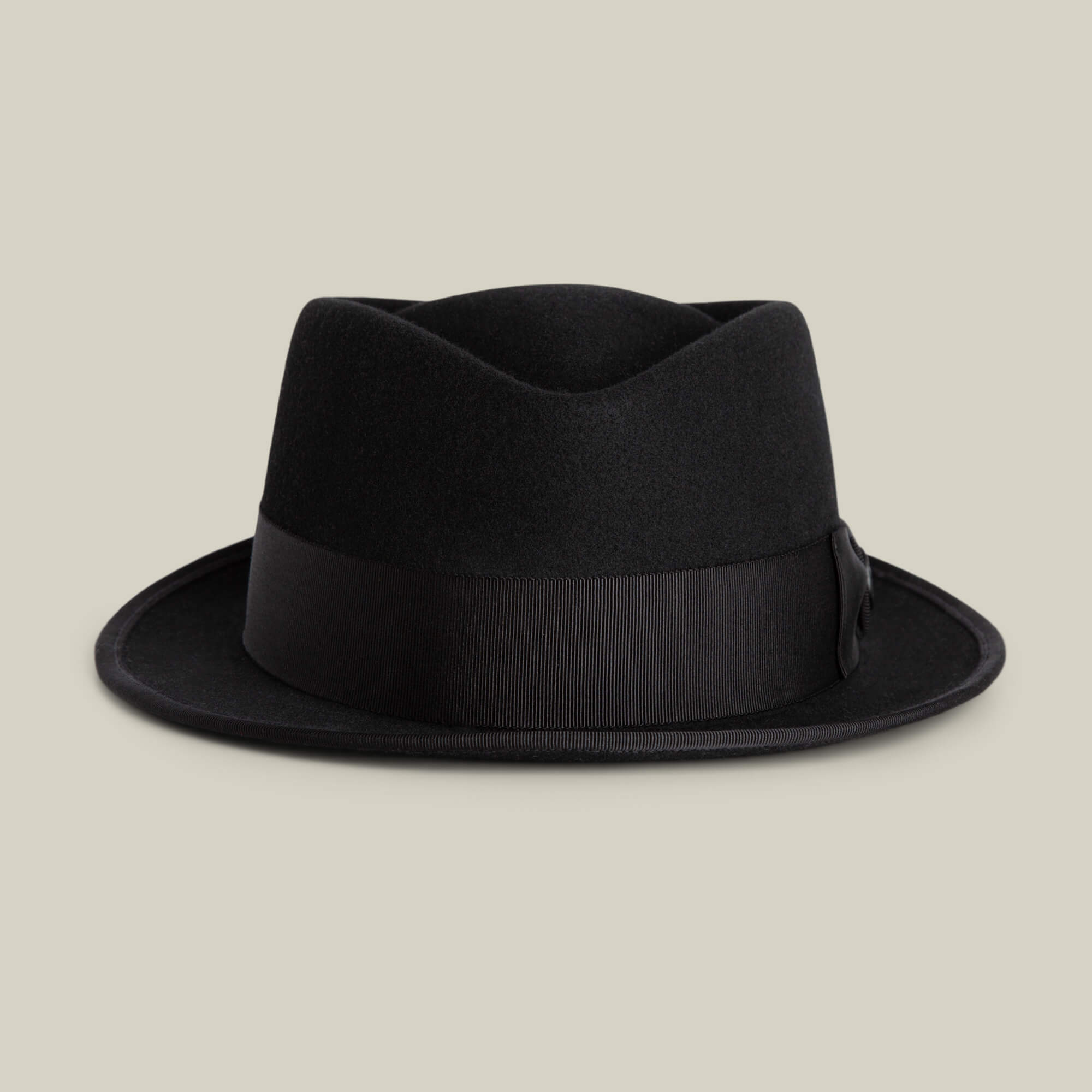 The Goorin Bros. Slick Carter is a black felt fedora hat with a wide ribbon band and short wool brim, inspired by Slick Carter’s effortless style, shown against a plain beige background.