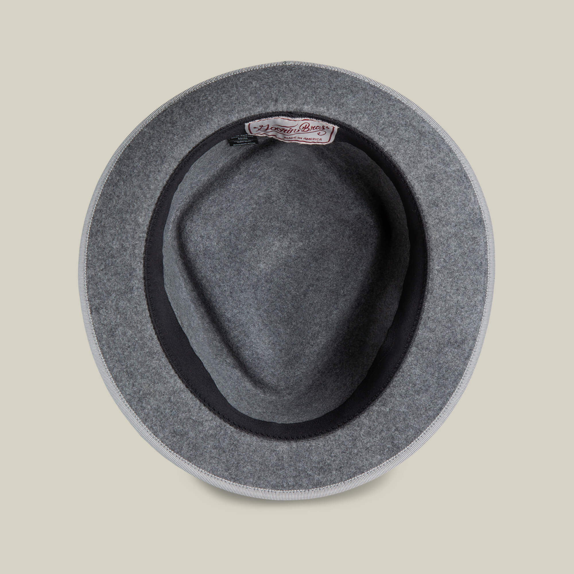 Top view of the Slick Carter gray wool short brim hat by Goorin Bros., featuring a black inner band and a fabric brand label sewn inside for effortless style.