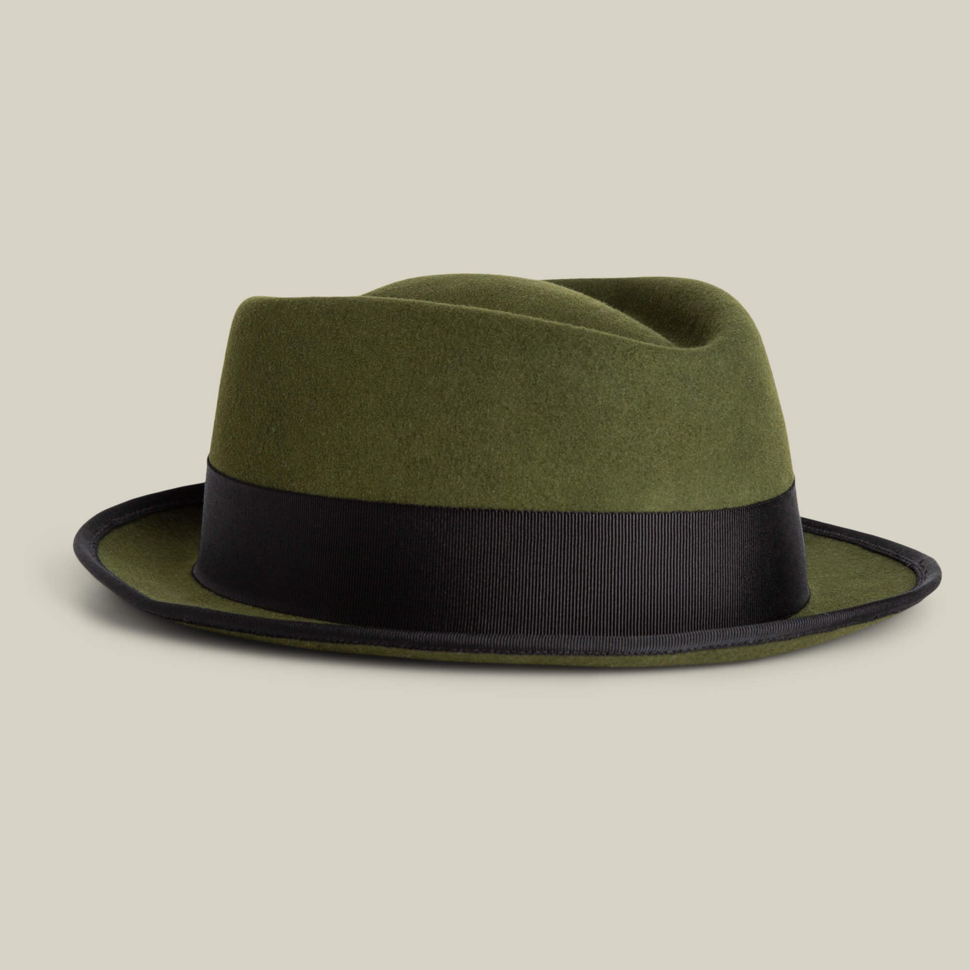 The Slick Carter by Goorin Bros. is an olive green wool short brim fedora with a wide black band, shown on a plain beige background—ideal for effortlessly elevating your style.