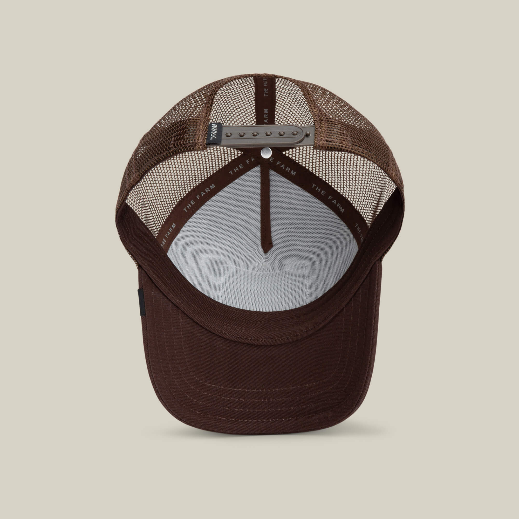 A brown mesh-back trucker baseball hat, The Panther by Goorin Bros., shown from above highlighting the inner crown, adjustable snapback strap, and sweatband.