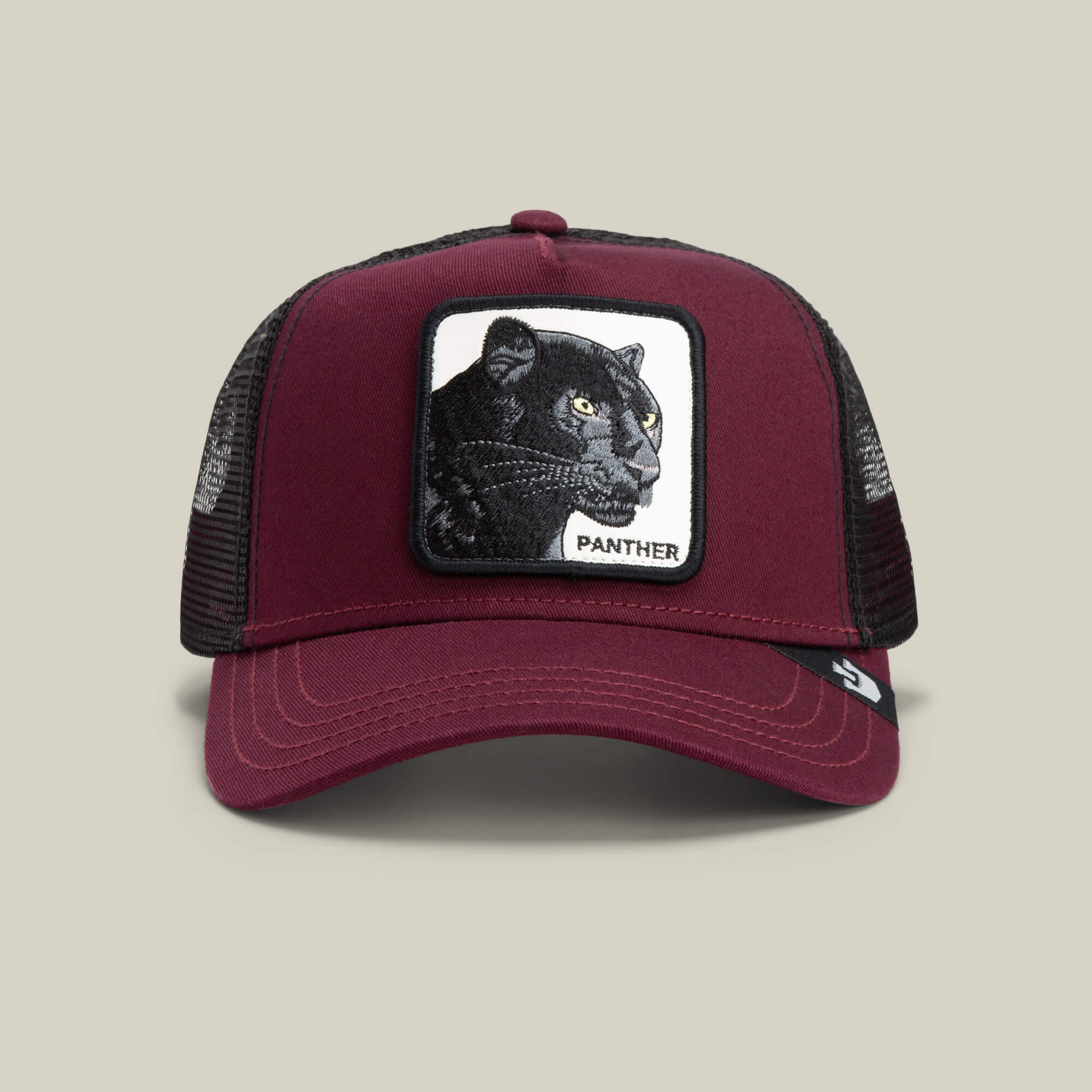 The Panther by Goorin Bros. is a burgundy trucker baseball hat with a mesh back and a front patch showing an embroidered black panther and “PANTHER” in capitals—ideal for fans of The Farm style.