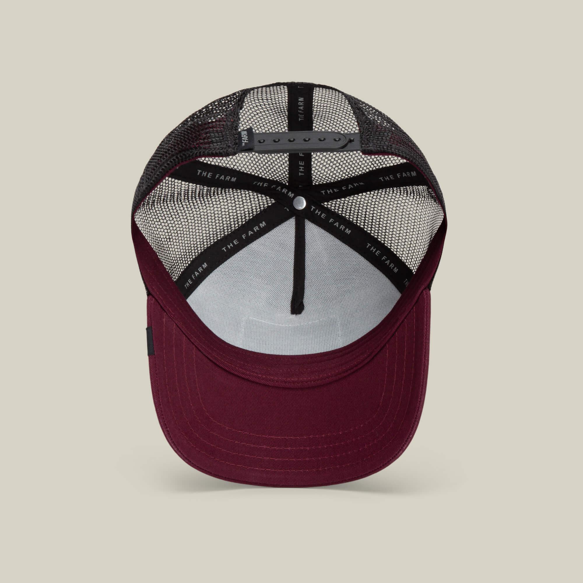 A maroon and black mesh trucker baseball hat, The Panther by Goorin Bros., shown from the inside with an adjustable snapback closure and branded inner lining.
