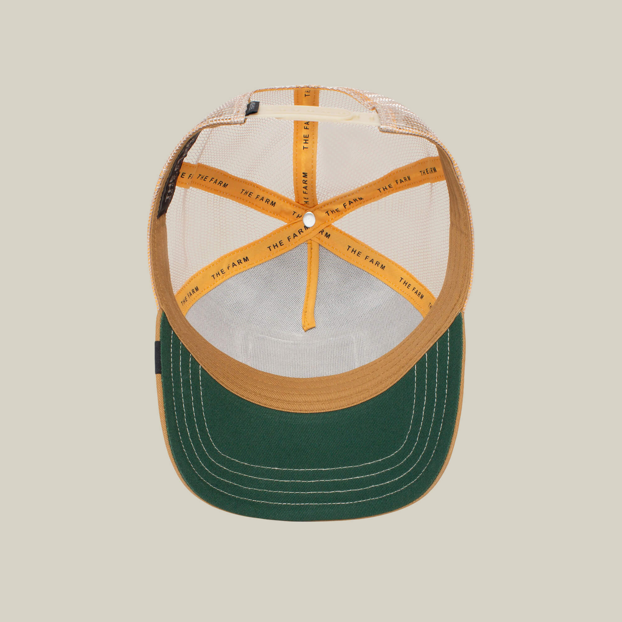 A top-view of The Queen Bee by The Farm—this mesh-back trucker hat features tan trim, a green brim, and interior orange bands labeled THE FARM, designed for those who wear their crown with pride.