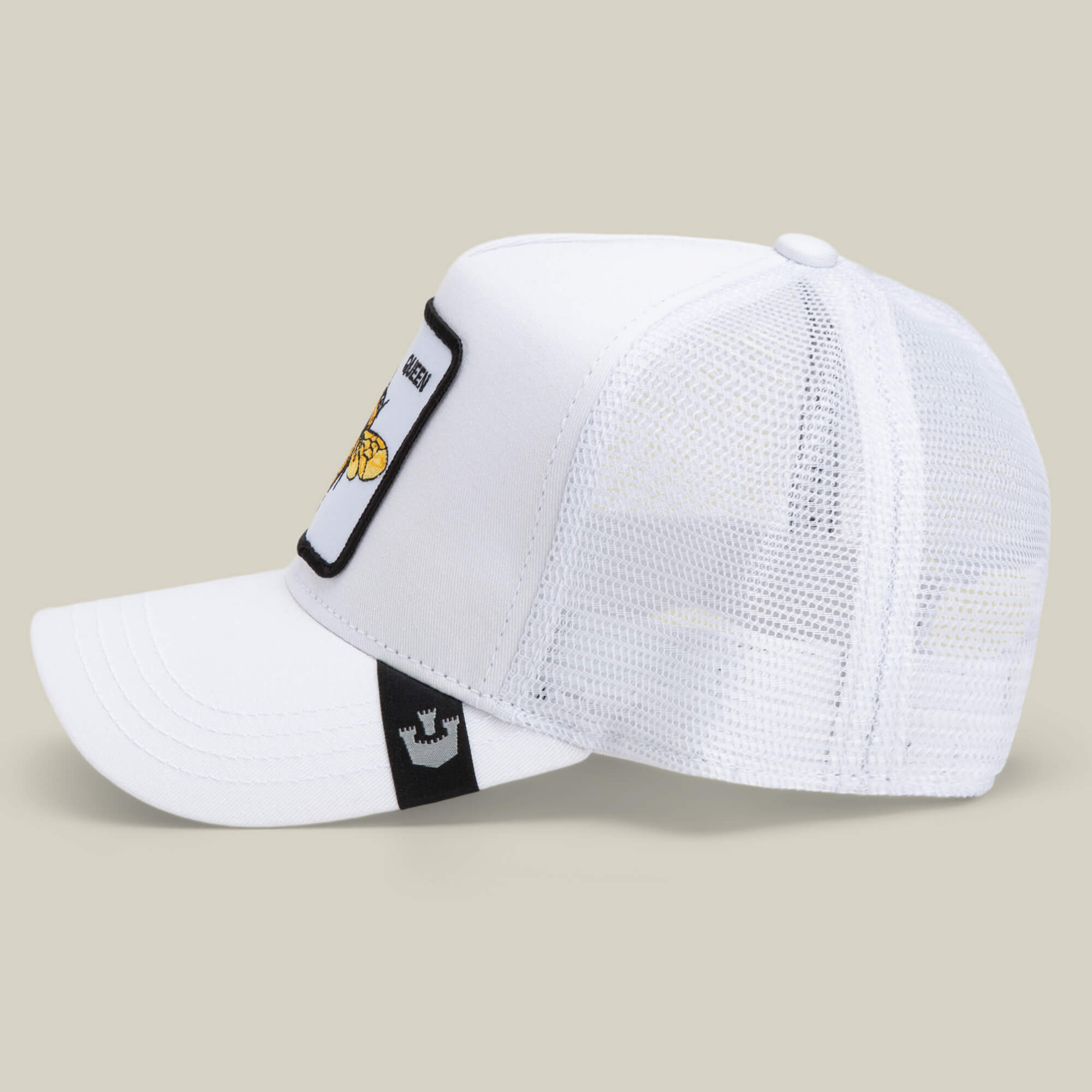 The Queen Bee by The Farm is a white mesh trucker cap with a flat brim, side fabric patch, and front embroidered crown—perfect for those who slay every look.