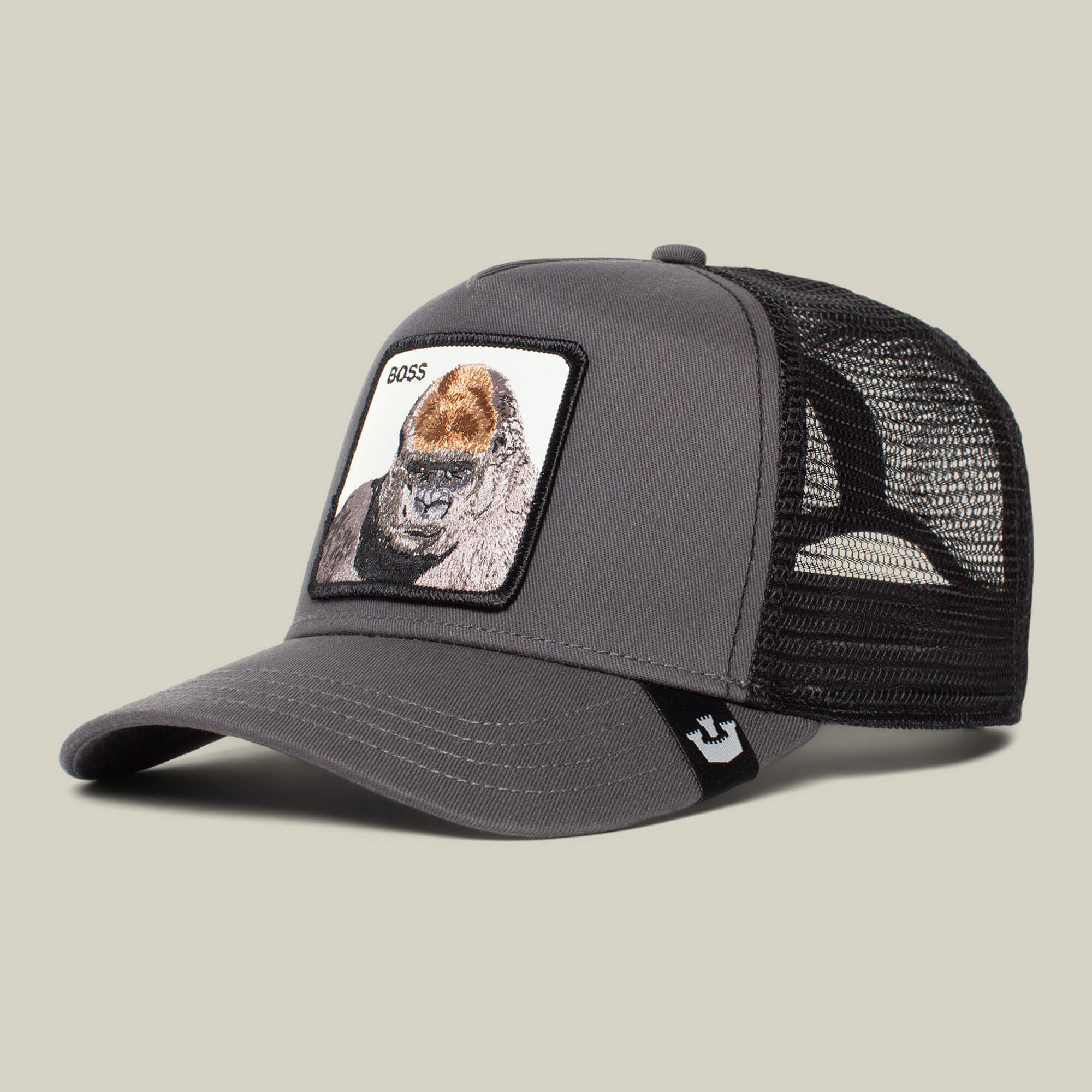 The Farm’s “The Boss” is a gray trucker cap with a black mesh back, featuring an 800-pound gorilla patch and “BOSS” on the front—add to cart for bold, movie theater-inspired style.