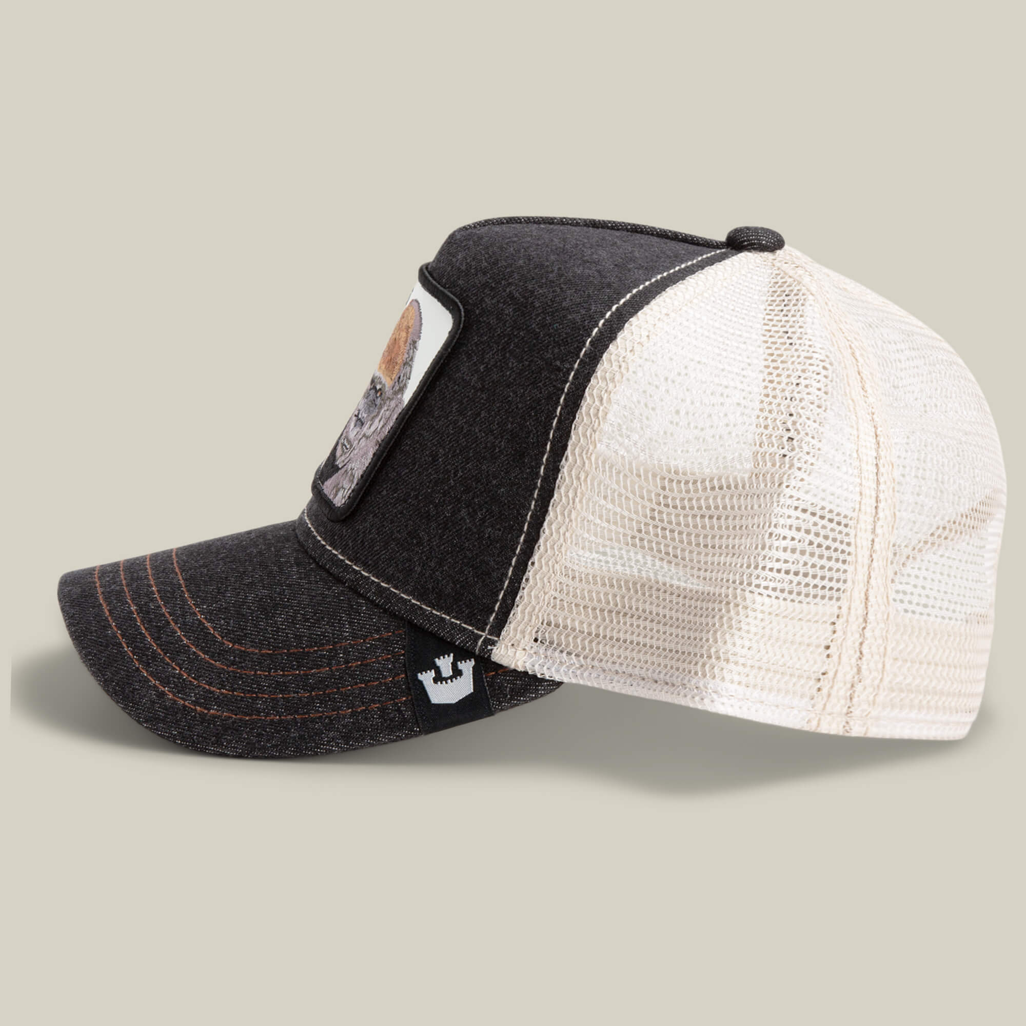 The Farm’s "The Boss" is a black and white mesh trucker hat with a front patch of an 800-pound gorilla and a crown logo tag on the brim, shown in profile view.