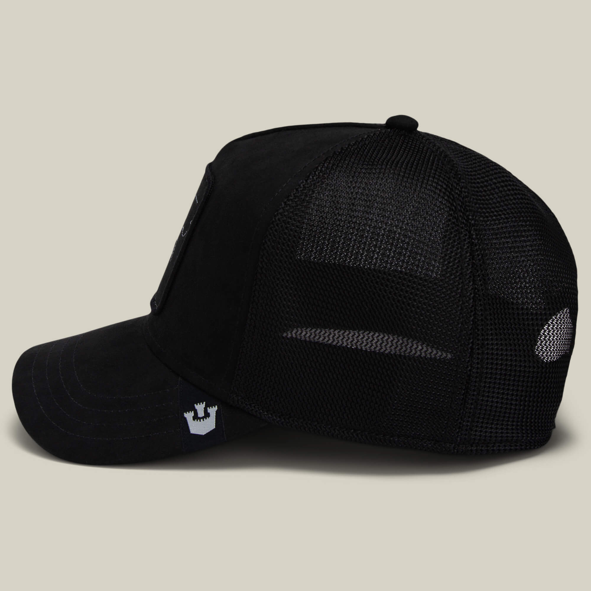 The Suede Spider by Goorin Bros.—a black mesh trucker hat with a curved bill, logo patch on the side, and adjustable snapback closure—makes a stylish or funny dad gift, shown on a plain light background.