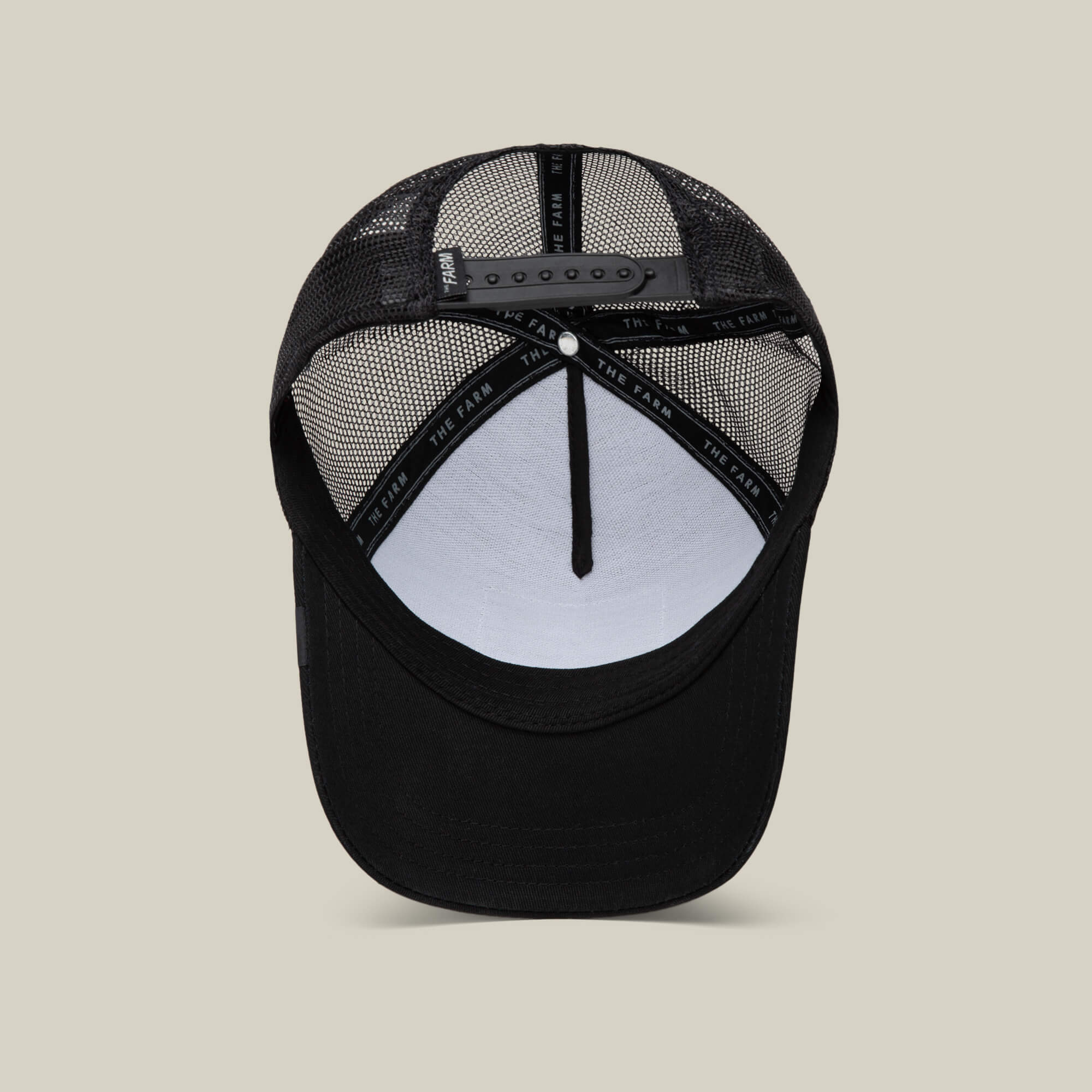 The Goorin Bros. EK65 Penguin cap features a black mesh back, adjustable snap closure, and visible internal seams—shown from below as part of a limited EK65 collab.