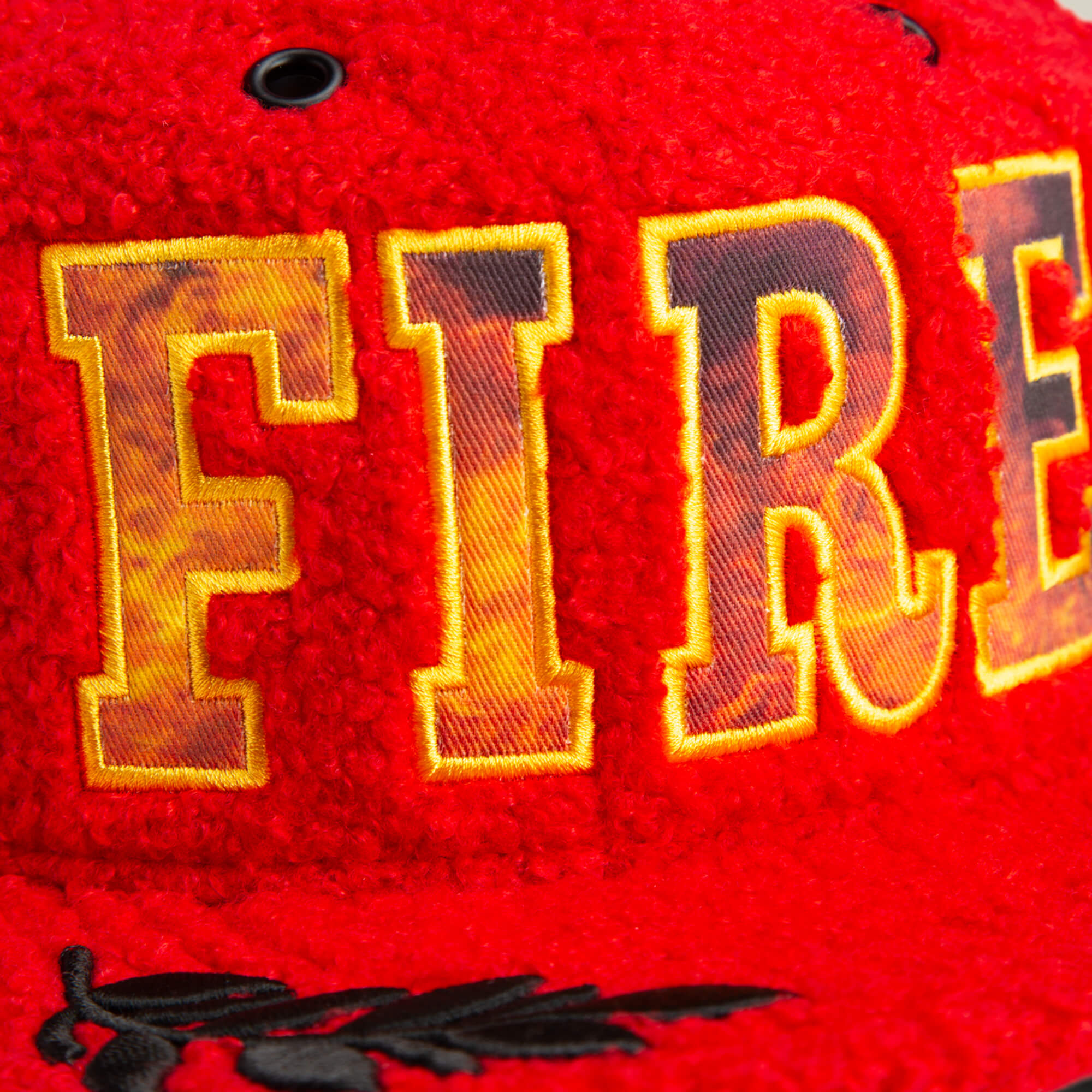 Close-up of the Hot Fire hat by Goorin Bros., showcasing bold yellow and black embroidered FIRE letters on the front.