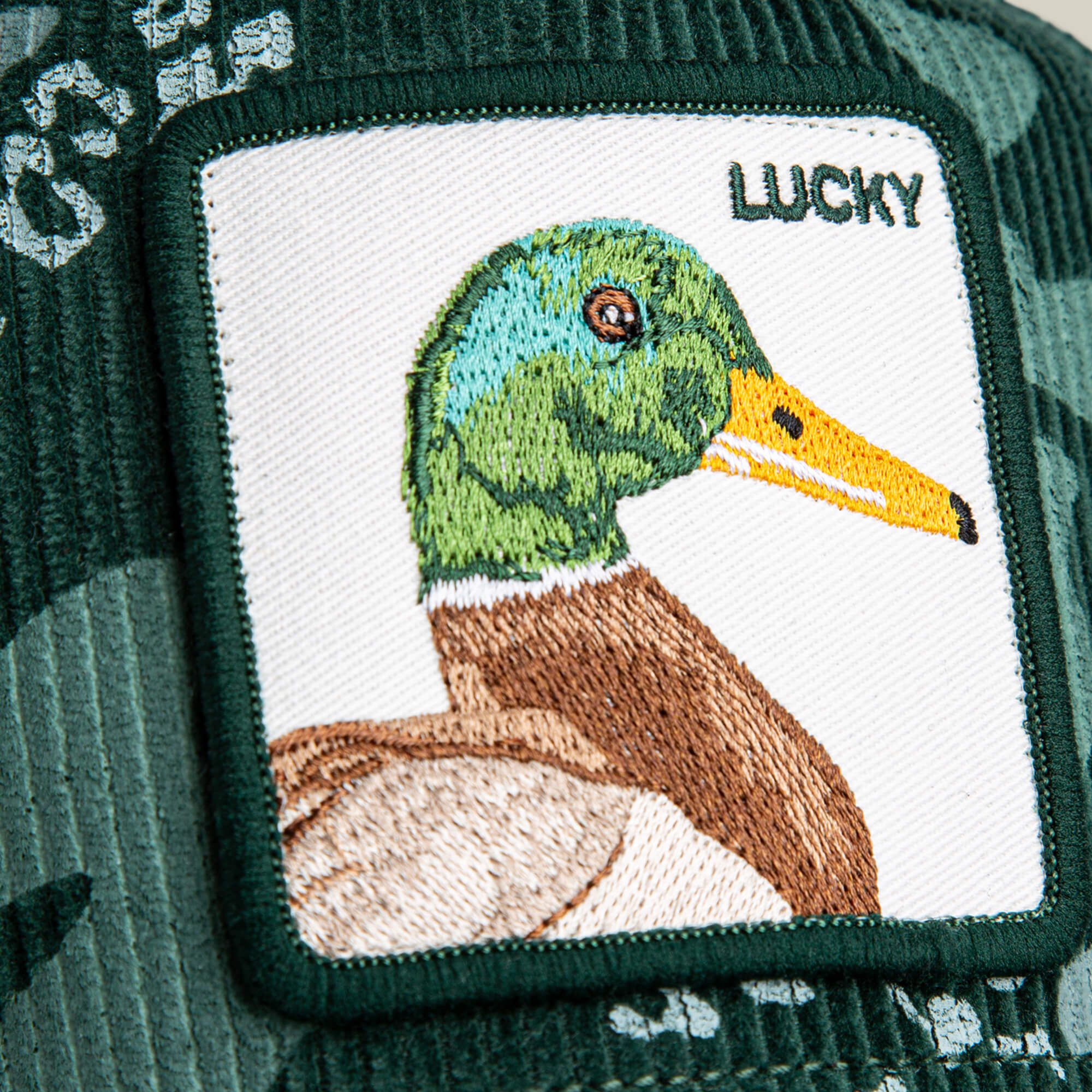 The Goorin Bros. Duck Camo patch features a mallard duck embroidered on forest green corduroy fabric.