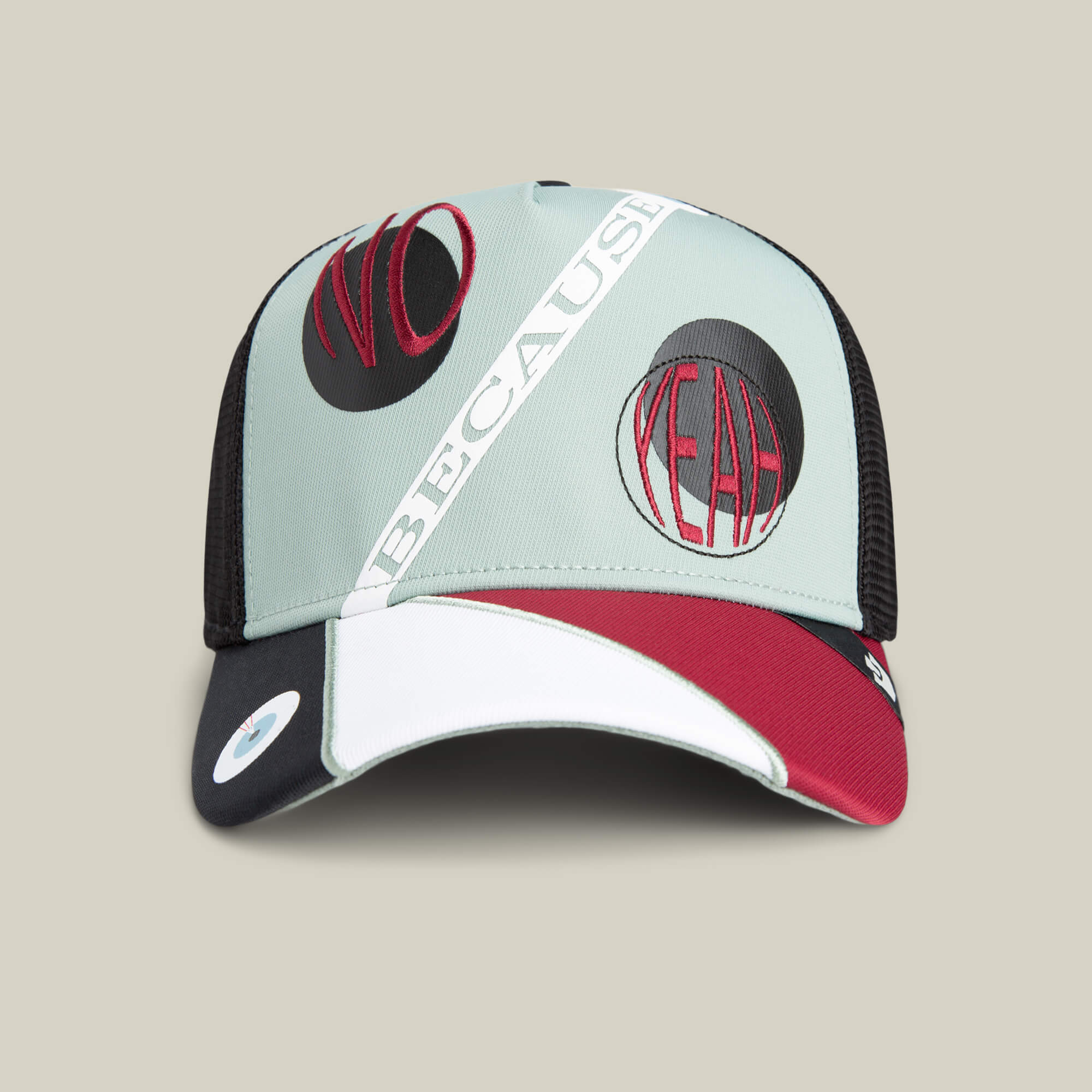The Means Agreed trucker hat by Goorin Bros. features bold NO, YEAH, and BECAUSE patches in black and red on a light green and black background—perfect to pair with your favorite tee for a confident, casual look.