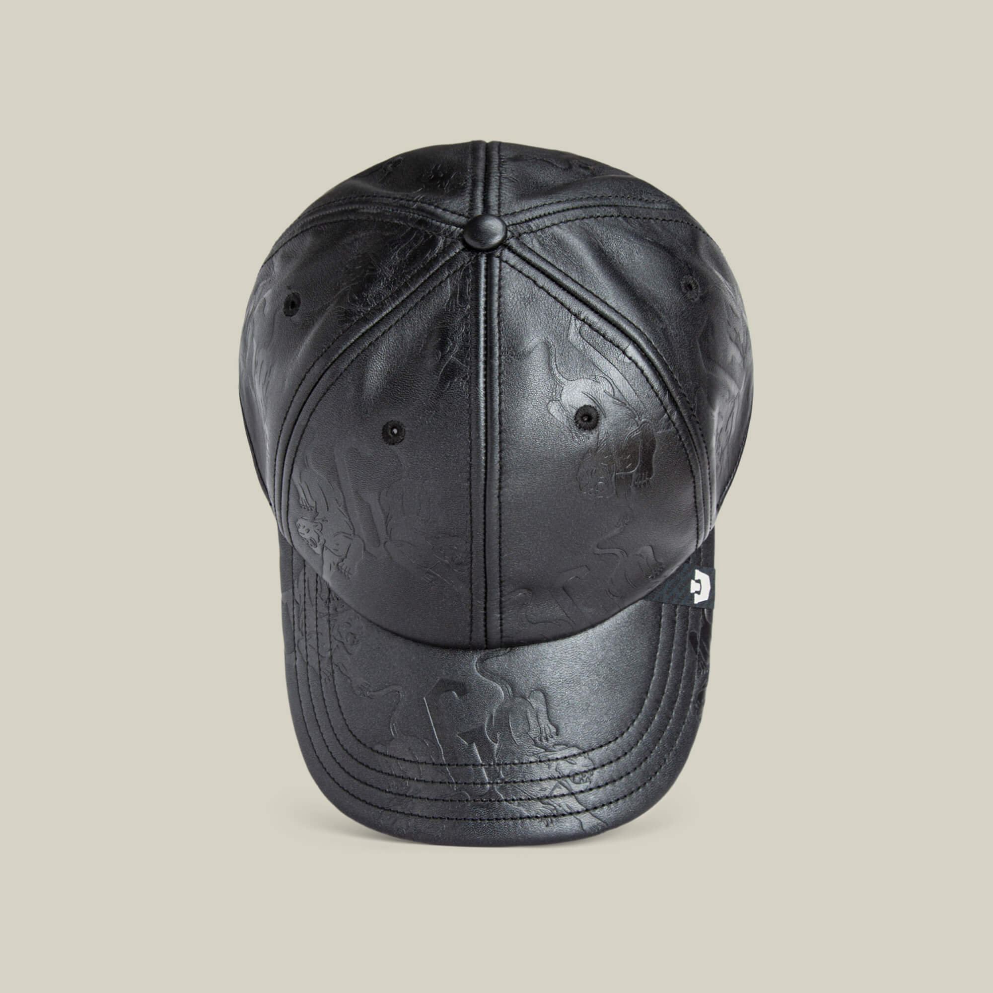 The Put a Panther On It cap by Goorin Bros. is a black leather baseball cap with subtle embossed patterns and a classic fit, shown from the front on a plain beige background.