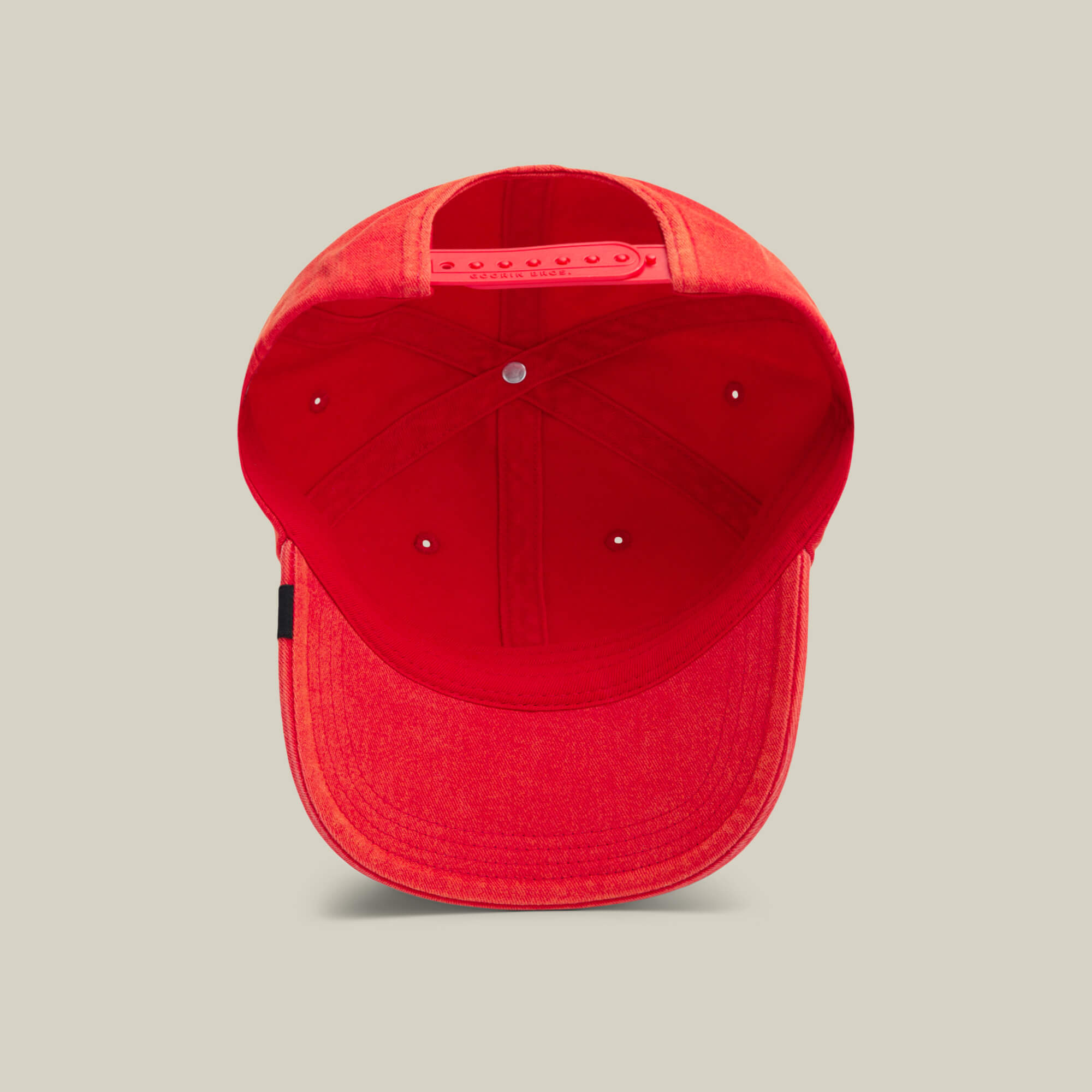 A red Goorin Bros. Papa Cap Italiano is shown from underneath, displaying the inner seams, sweatband, and adjustable snap closure at the back.