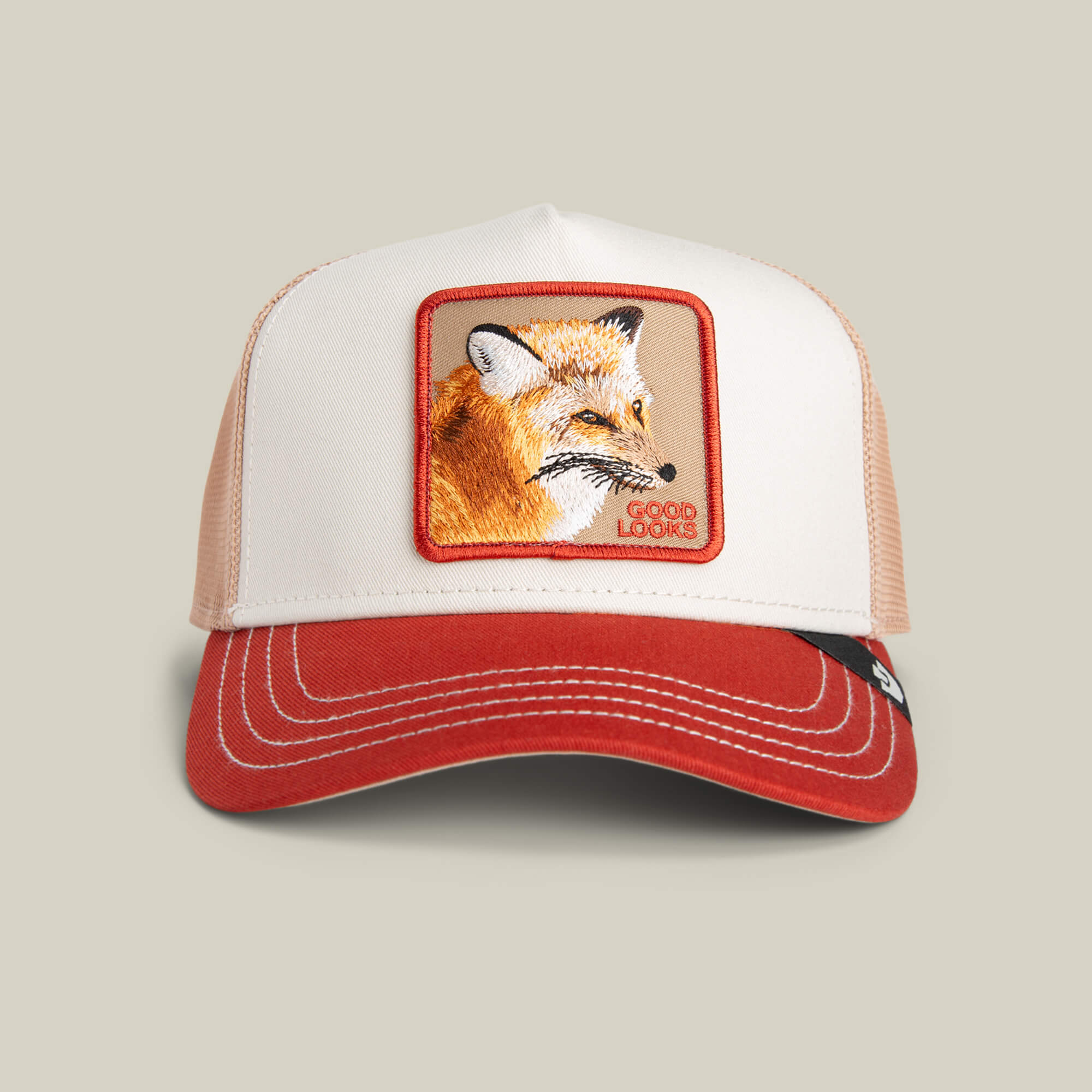 The Goorin Bros. Tricolor Fox is a tri-tone trucker hat with a red brim, mesh back, and a fox patch on the front with the words "GOOD LOOKS.