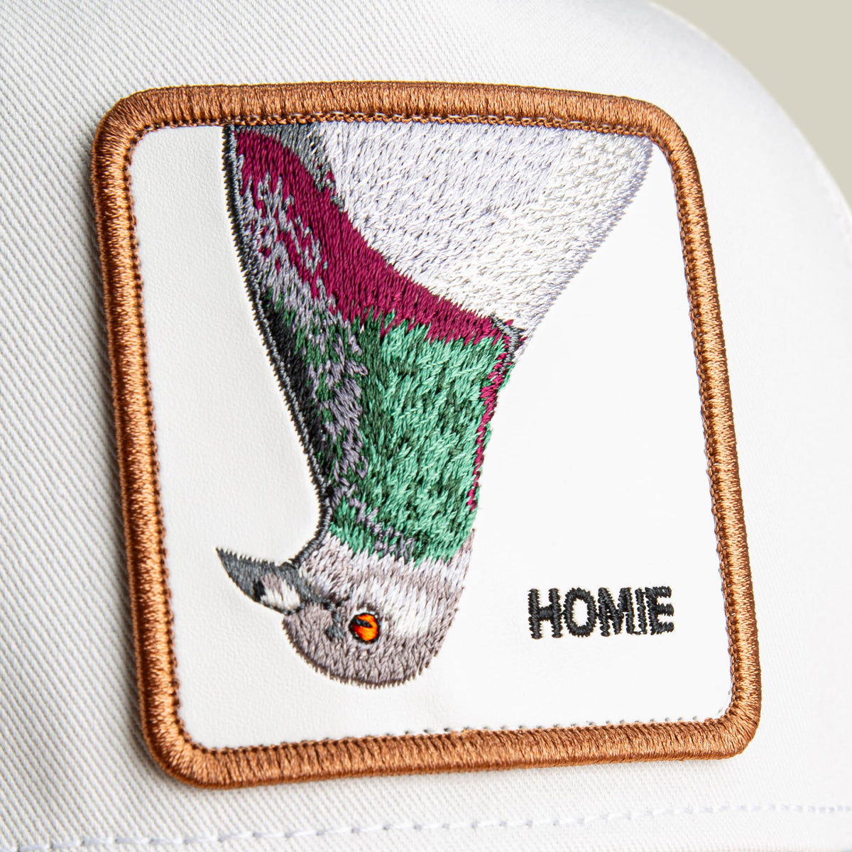 The Goorin Bros. Noegip is a square fabric patch featuring embroidered Palestinian flag colors in green, black, and white with a stylized bird design and the word "Home" in black text, bordered with tan stitching on a white background.