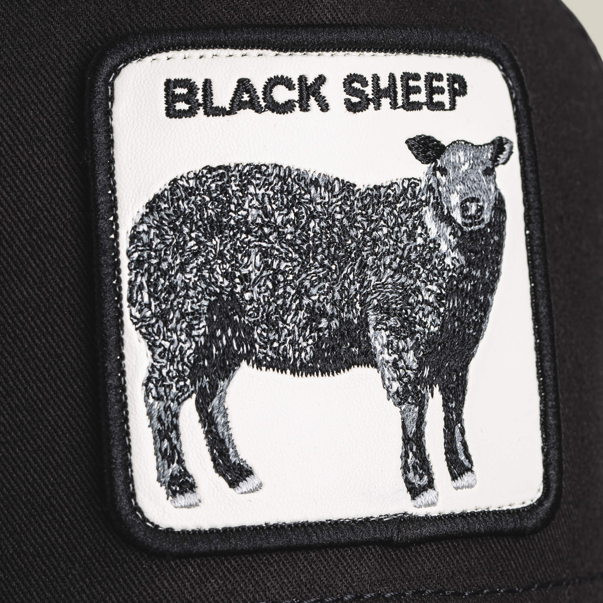 A close-up shows The Black Sheep patch by Goorin Bros., featuring a black sheep illustration and the words "BLACK SHEEP"—a nod to standing out from the crowd.
