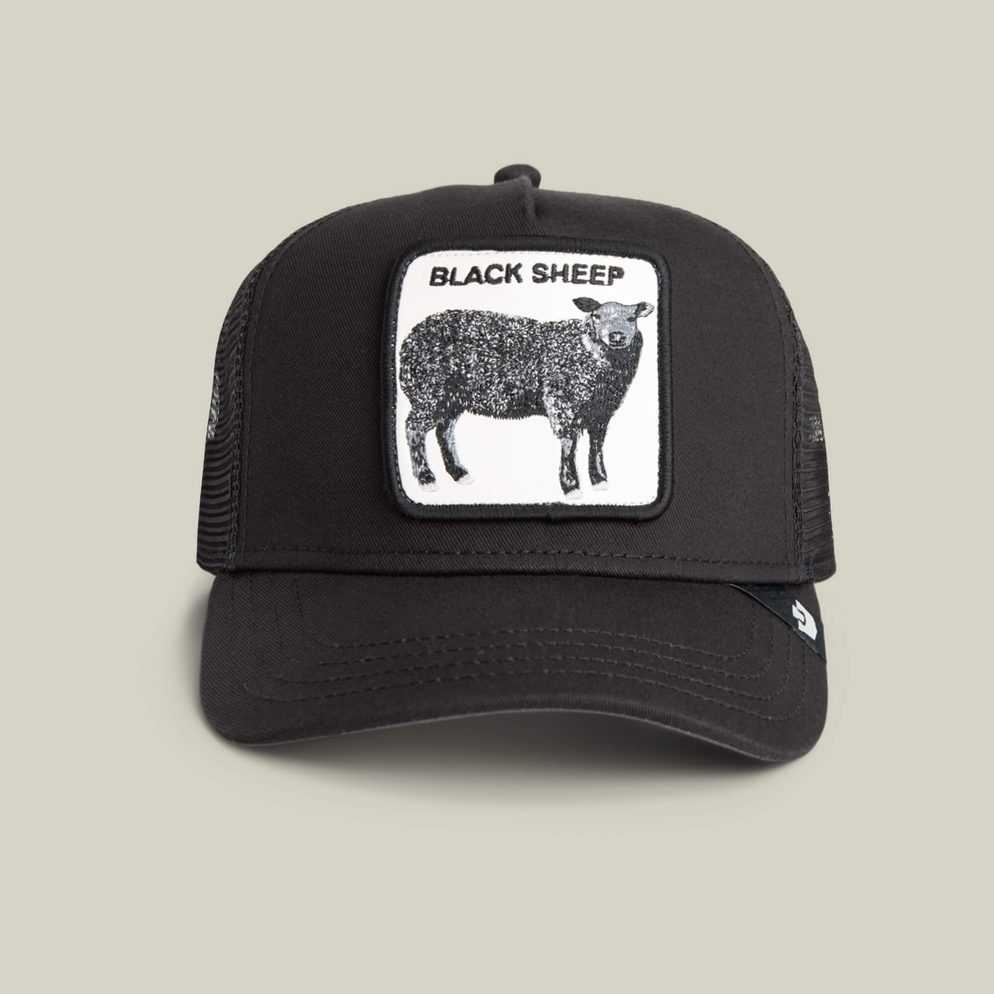 The Black Sheep by Goorin Bros. is a black trucker hat with a mesh back and a front patch of a black sheep and "BLACK SHEEP" text—ideal for those who like to stand out.