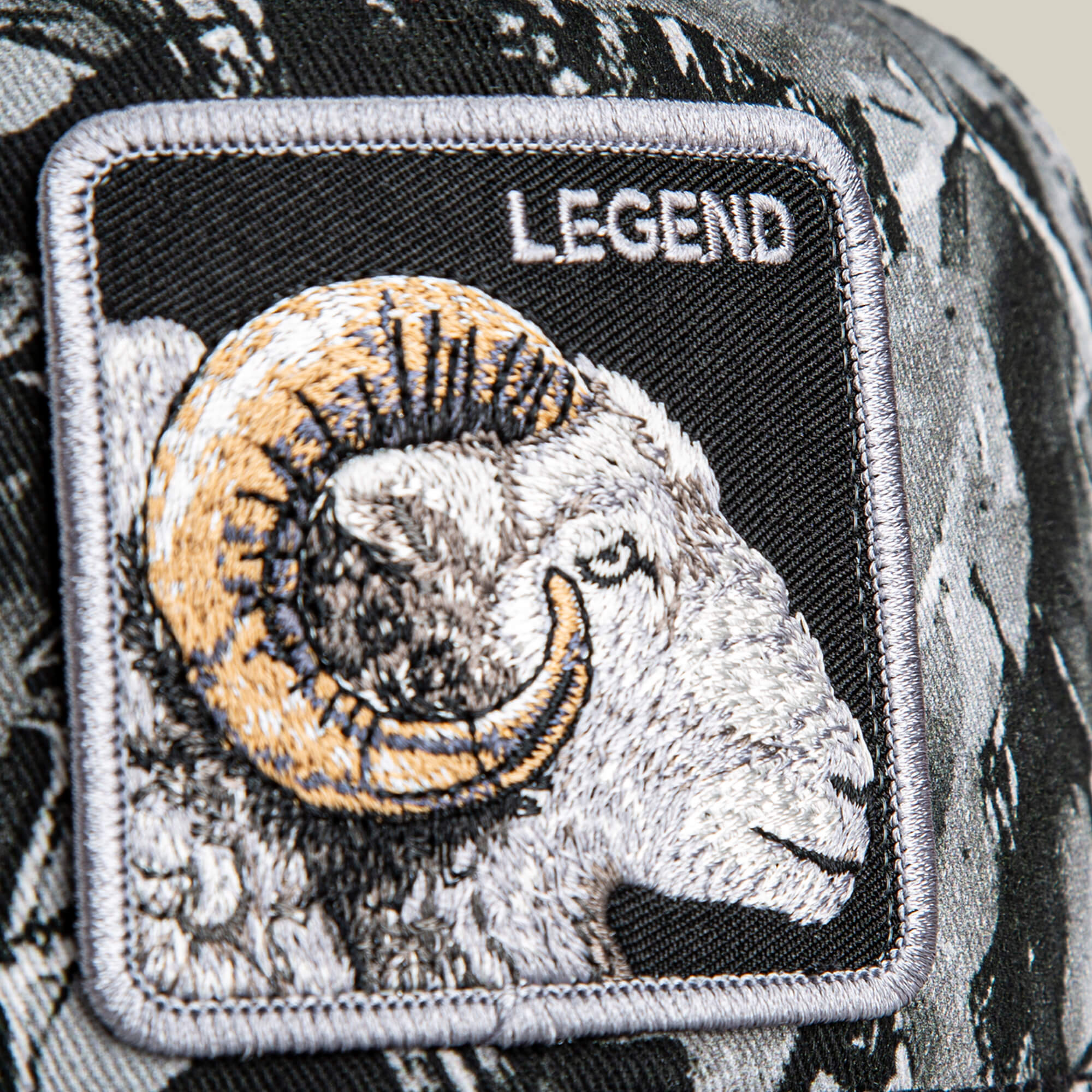 Close-up of the Goorin Bros. Legend Camo patch, featuring an embroidered ram and the word "LEGEND" on a frosted camo background.