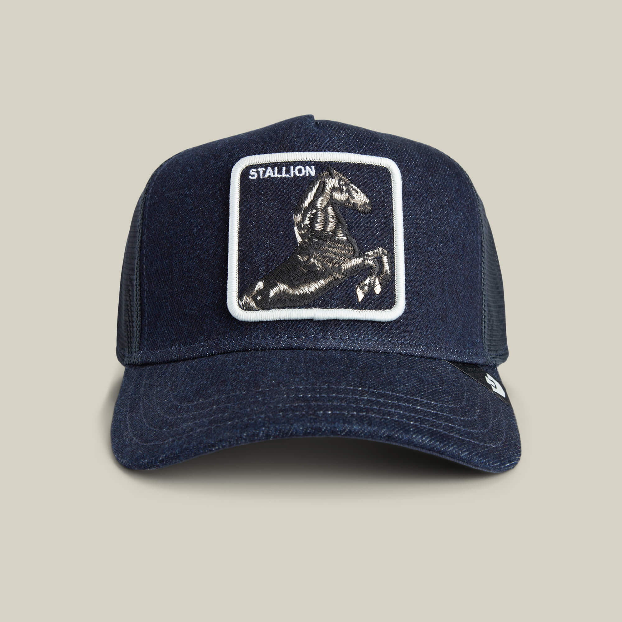 The Goorin Bros. Denim Stallion is a navy blue arena-style trucker cap with a mesh back and a front patch featuring an embroidered horse and the word STALLION.