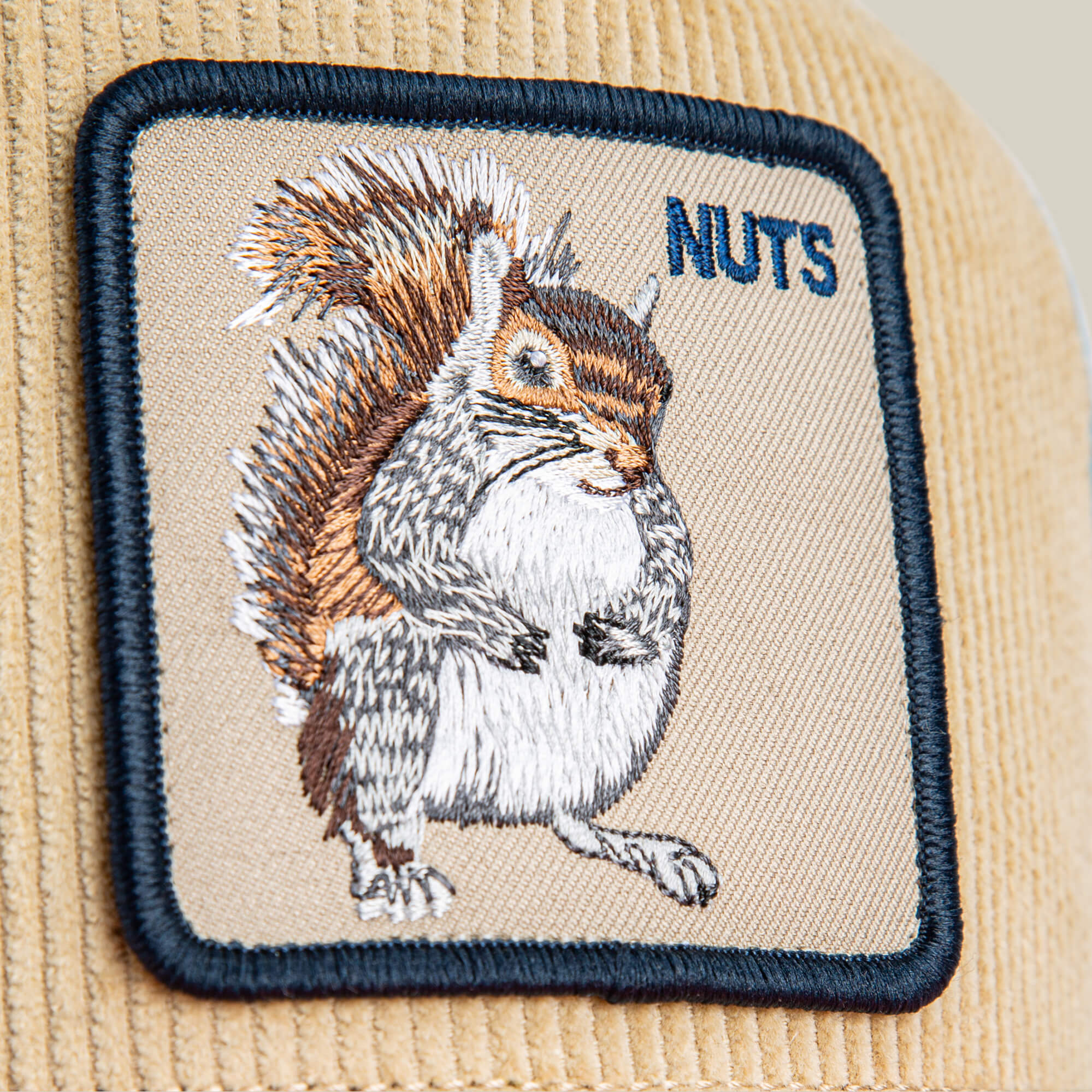 A beige corduroy patch with an embroidered squirrel and "NUTS" in blue thread adds forest flair to the Goorin Bros. Nuts Remix hat.