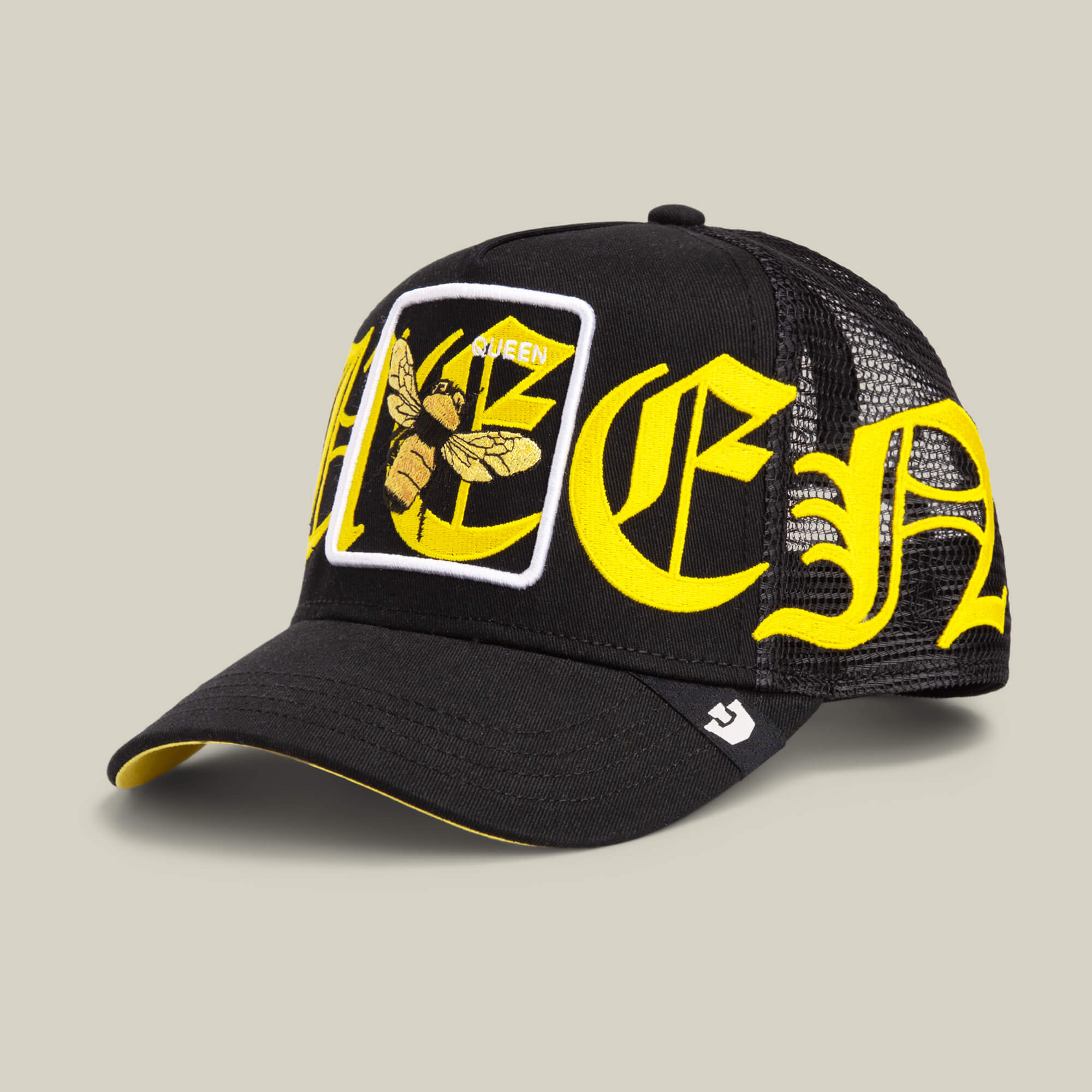 The Goorin Bros. Old English Queen cap features a black and yellow mesh design, bold lettering, a QUEEN bee patch, and yellow accents on the brim and underside.