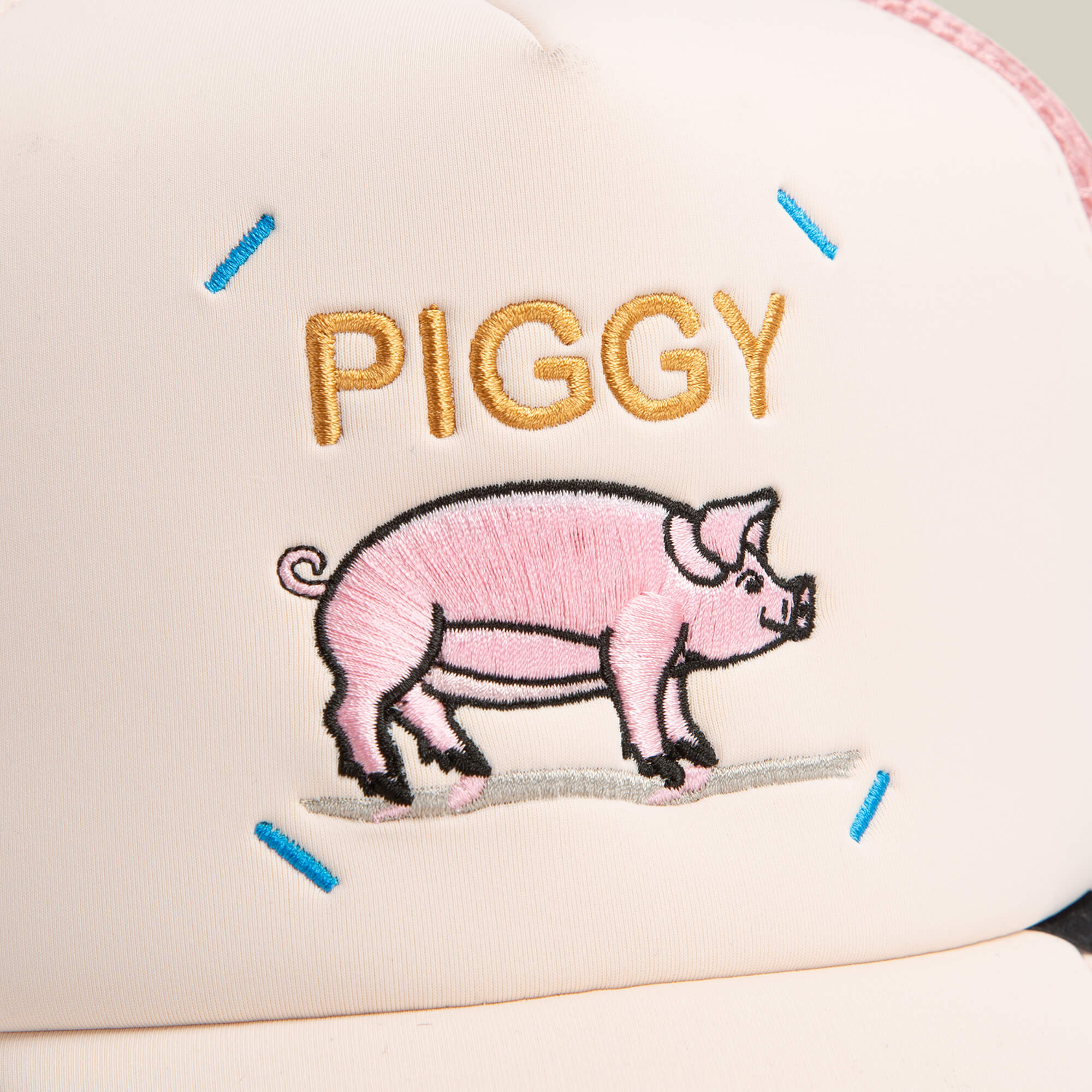 A close-up of the Goorin Bros. Neo Farm - Piggy Pig hat, featuring "PIGGY" stitched above an embroidered pink pig, blue corner stitches, and a breathable mesh back for comfort.