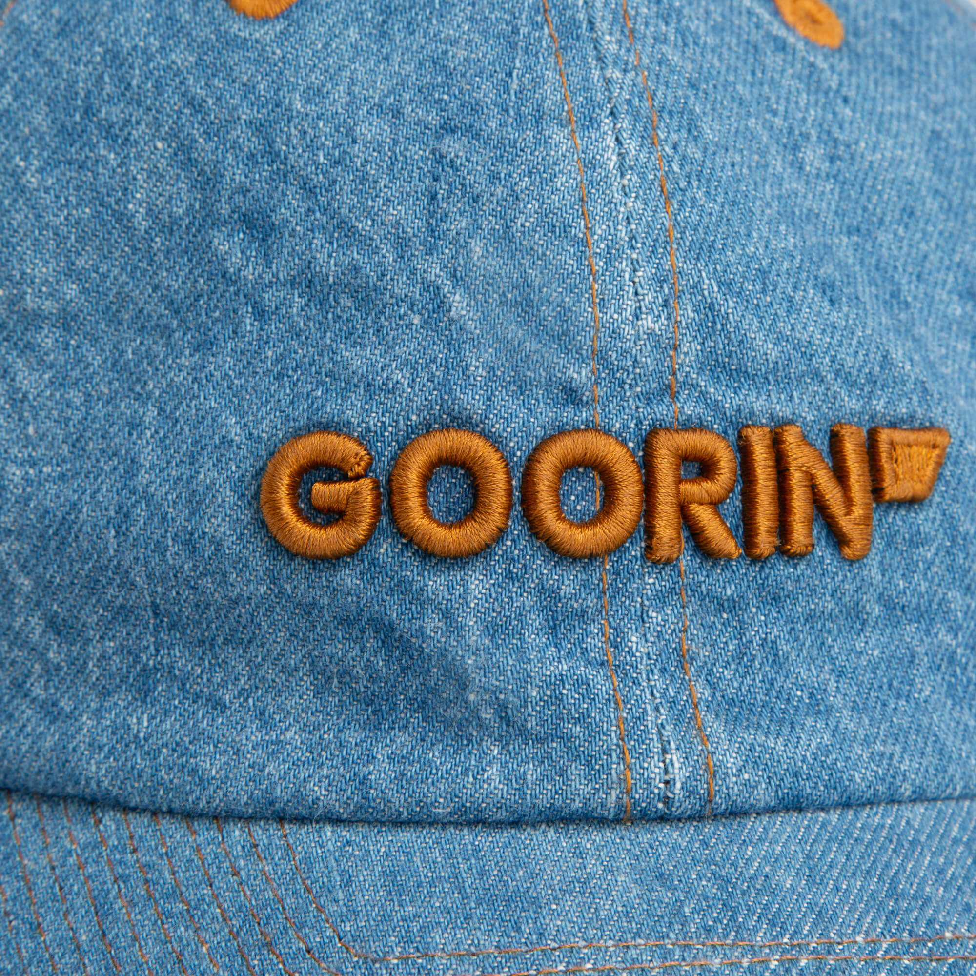 Close-up of the Papa Core Denim hat by Goorin Bros., featuring a classic low profile design with the brand's wordmark embroidered in brown on the blue denim front.