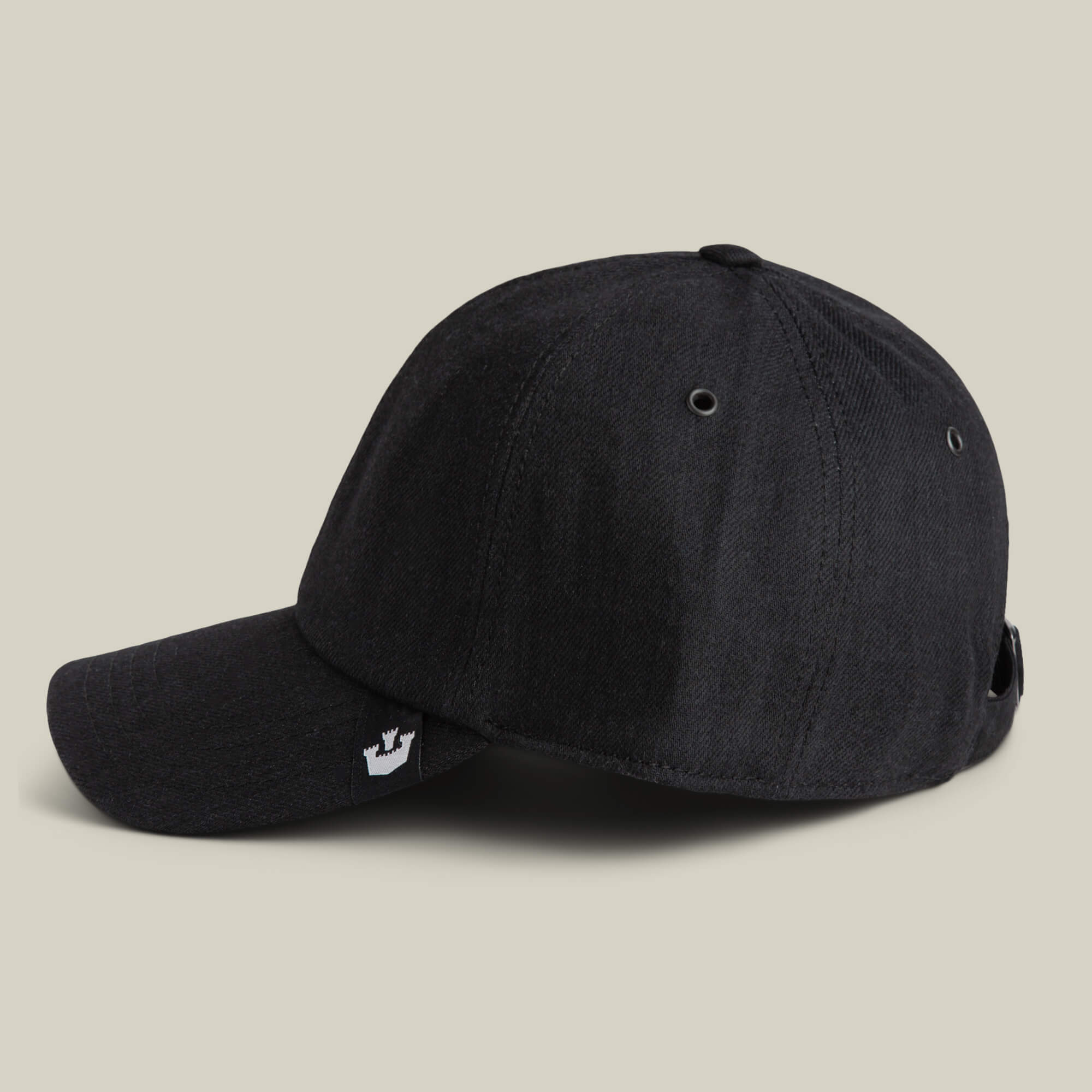 The Clean Denim Papa by Goorin Bros. is a black denim dad cap with a curved brim, metal eyelets, and a small white crown logo tag, displayed on a plain beige background.