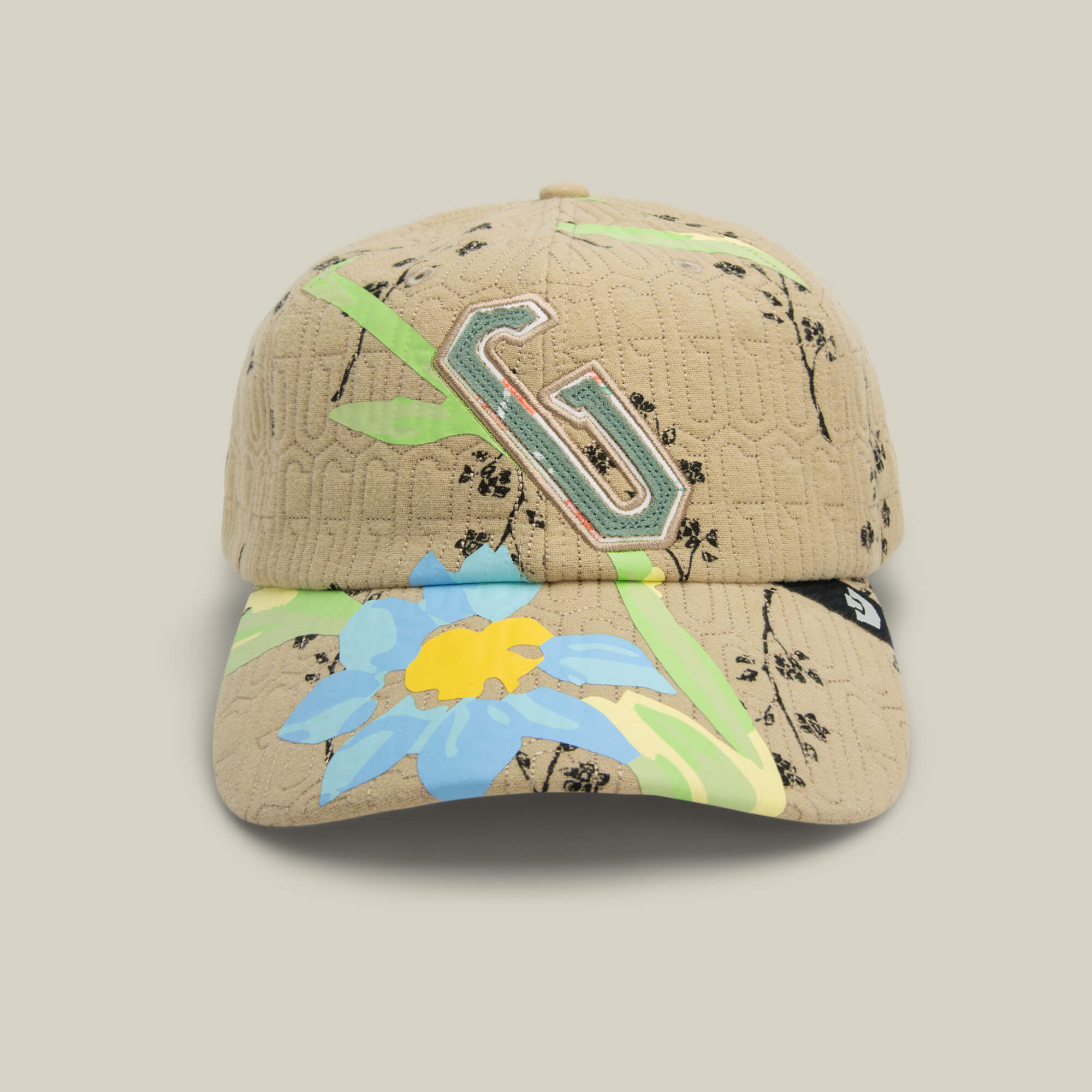 The Goorin Bros. Vol. 1 - Quiltbag: G Papa hat in SCOUT features quilted beige fabric with a large embroidered G, blue and yellow floral graphics, and green leaf touches—your perfect floral cap for any occasion.