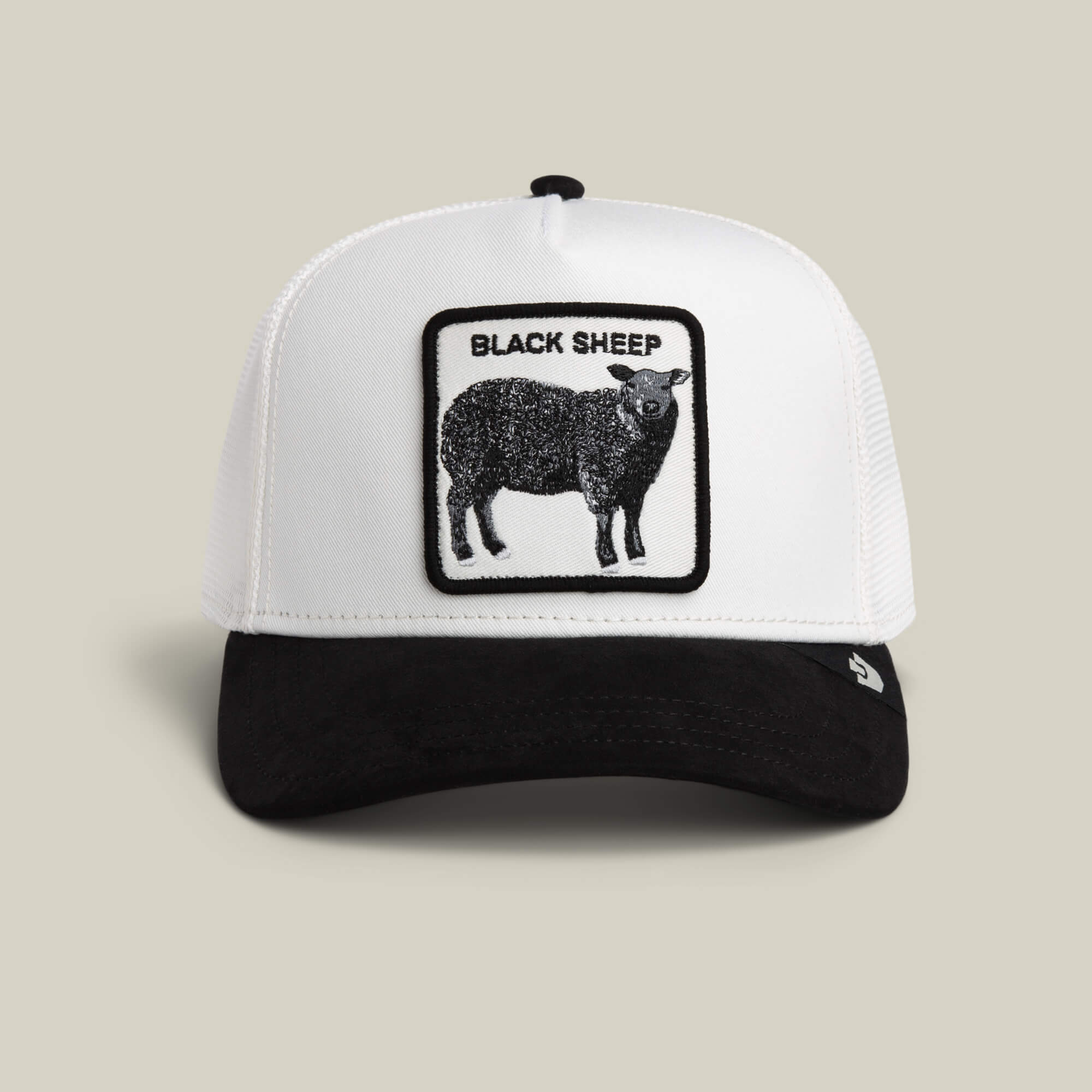 The Goorin Bros. Suede Sheep trucker hat in DUST / VOID features a suede feel and a black sheep patch with BLACK SHEEP text on the front in classic style.