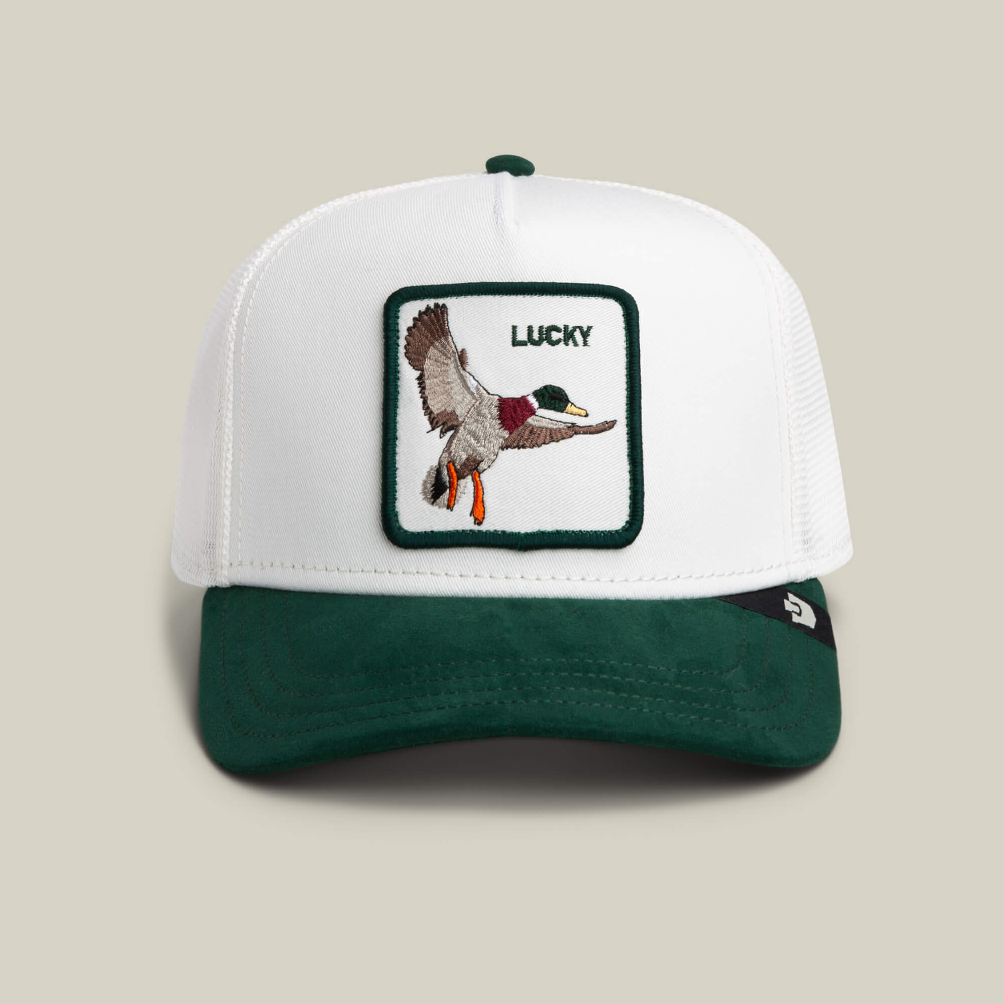The Goorin Bros. Suede Duck cap in DUST / GUARD features a suede brim and patch with a flying duck, plus “LUCKY” embroidered above.