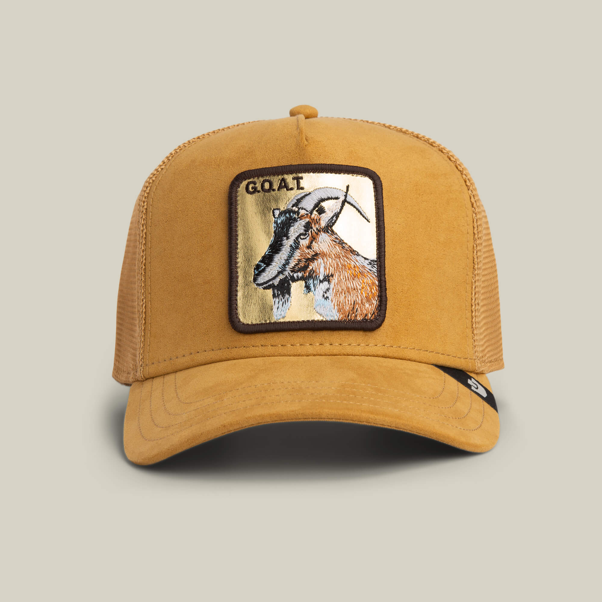 The Goorin Bros. Golden Goat trucker hat in AMBER features a suede front, mesh back, and an embroidered goat patch with bold G.O.A.T. text for standout style.