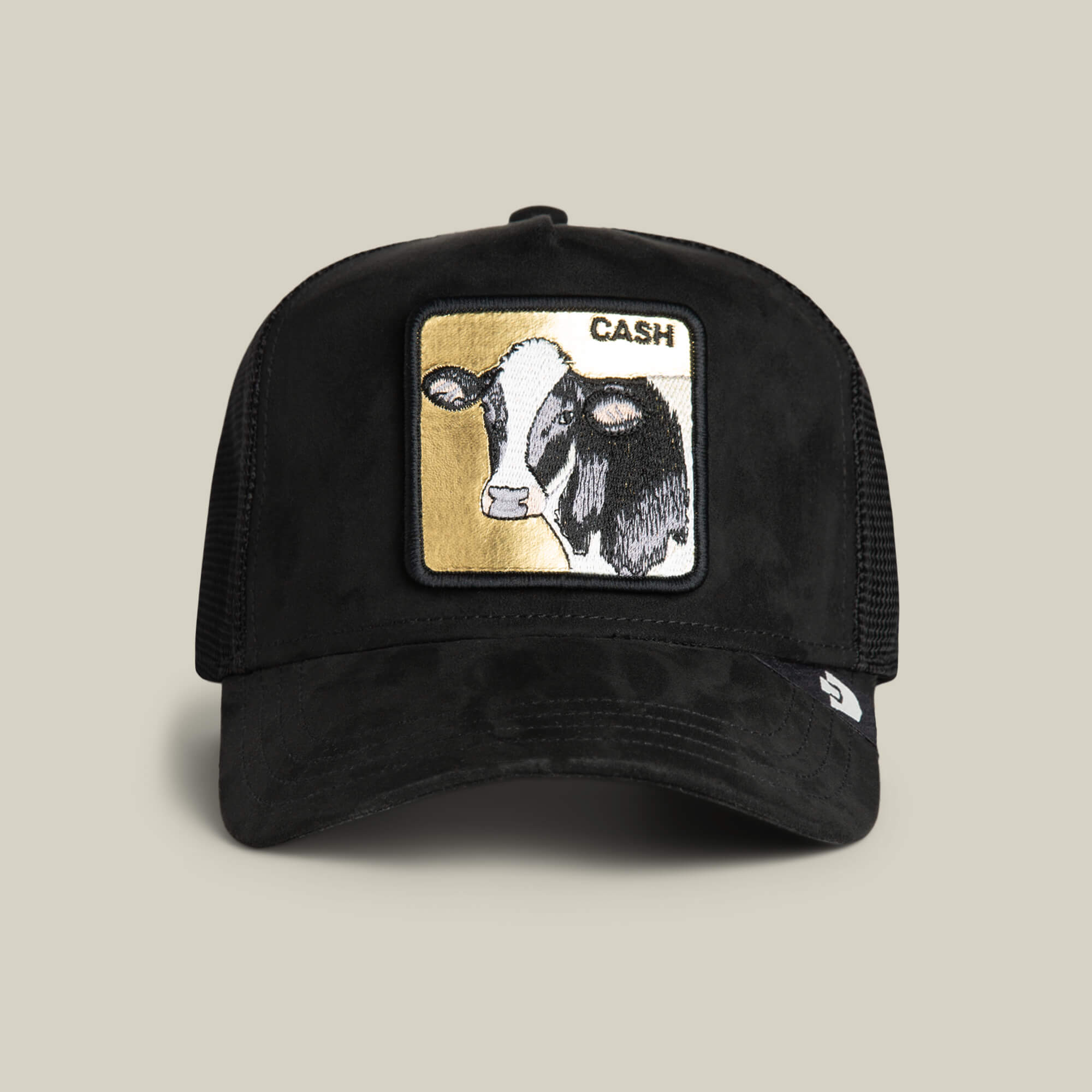 VOID trucker hat by Goorin Bros., called Golden Cow, featuring a mesh back, black suede accents, and a stitched cow patch labeled CASH on the front.