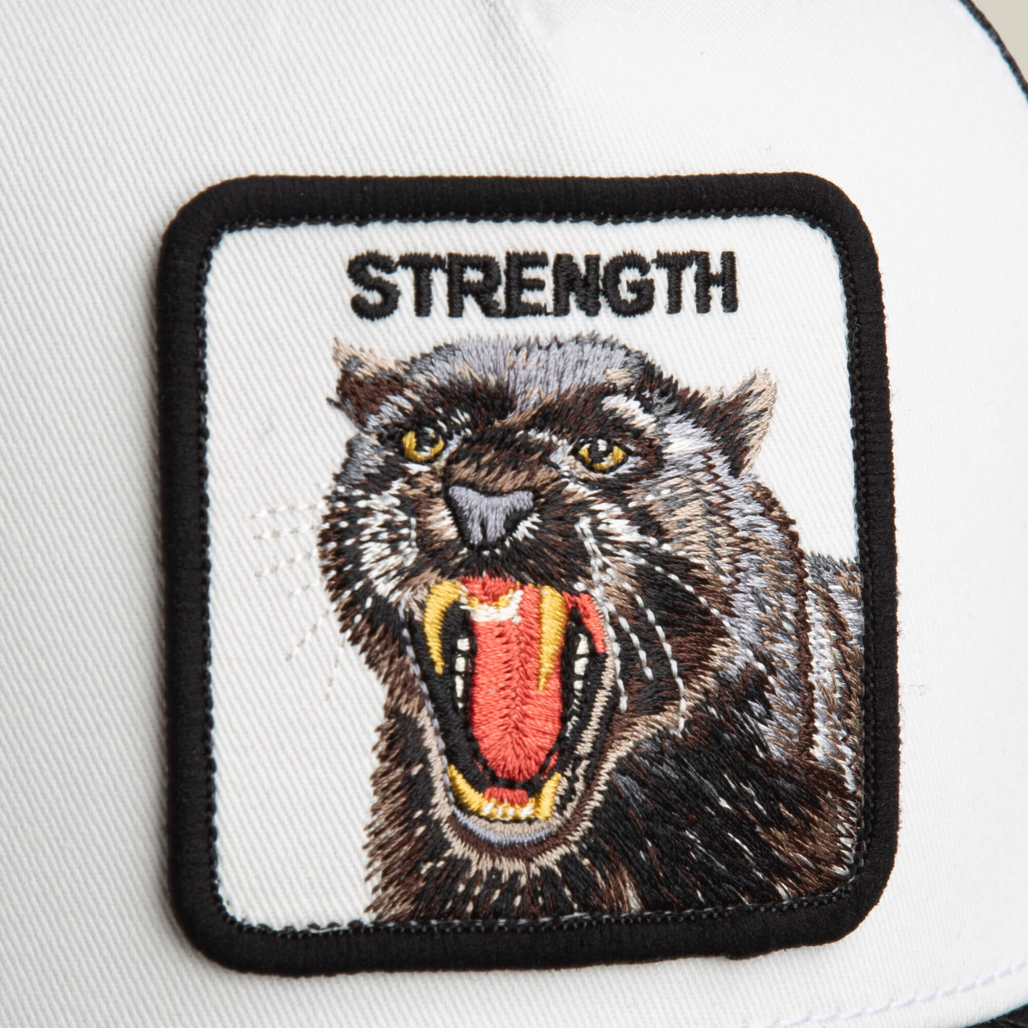 The Strength Panther by Goorin Bros. is a black and white hat with a square patch showing an embroidered snarling black panther and "STRENGTH" above it.