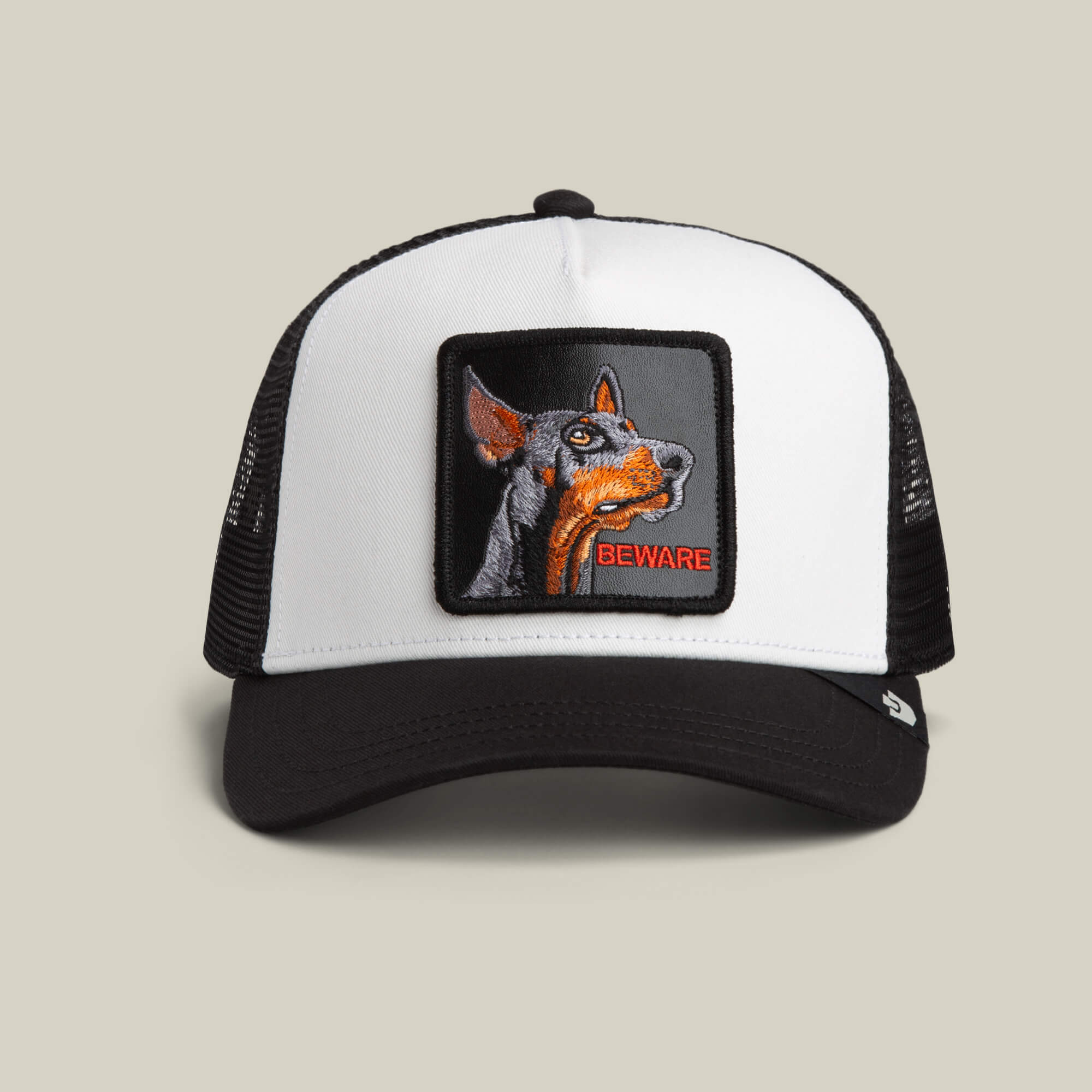 The Goorin Bros. "The Beware Dog" trucker hat in DUST or VOID features a mesh back and an embroidered Doberman with the word BEWARE on the front.
