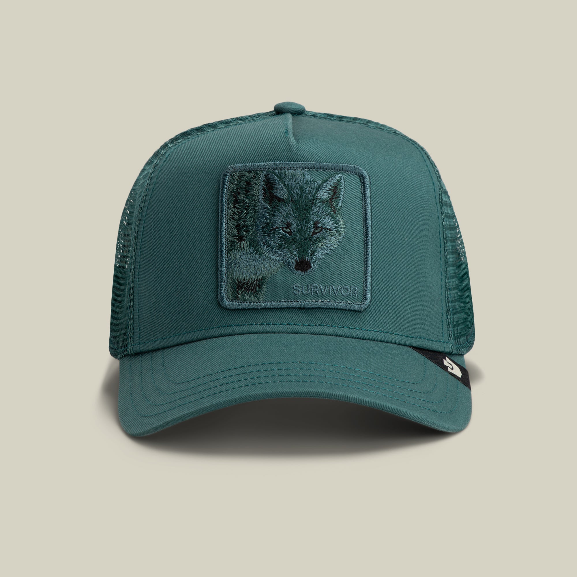 The Goorin Bros. Mirage Survivor trucker hat in SEA features mesh sides and an embroidered SURVIVOR patch on the front panel.