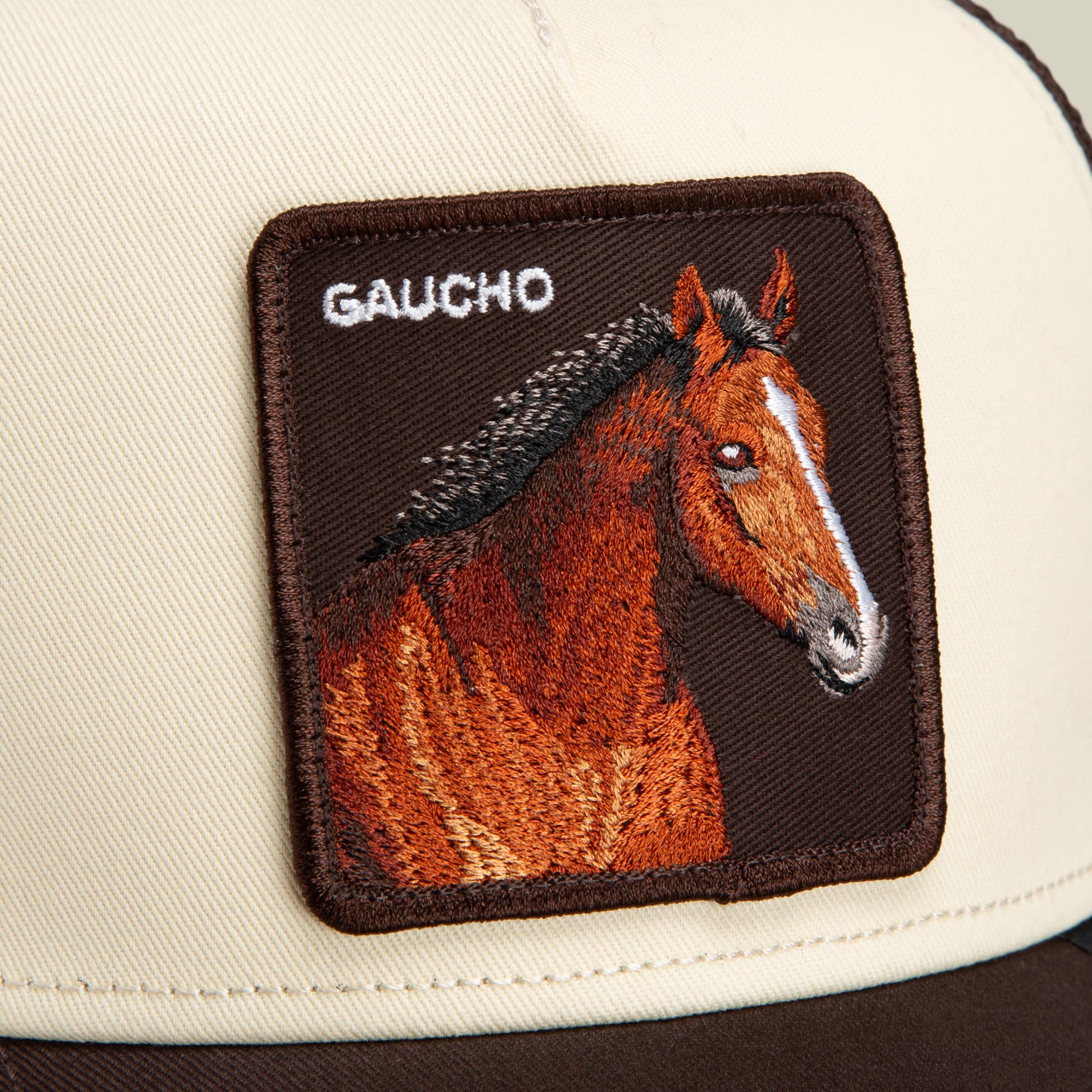Close-up of the Goorin Bros. Gaucho Trucker cap in an earthy beige and brown colorway, featuring an embroidered horse patch with “GAUCHO” above the image.
