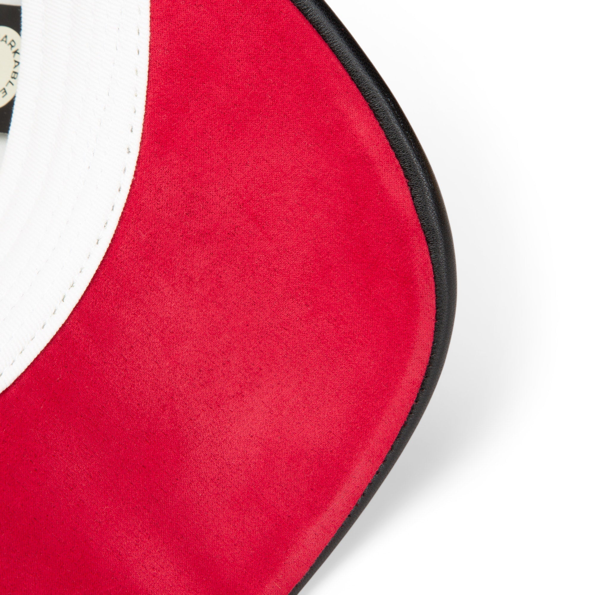 Close-up of the red suede brim and white crown of the Amor baseball cap by Goorin Bros., featuring a black edge trim—perfect to pair with your favorite necklace in this Friday drop.
