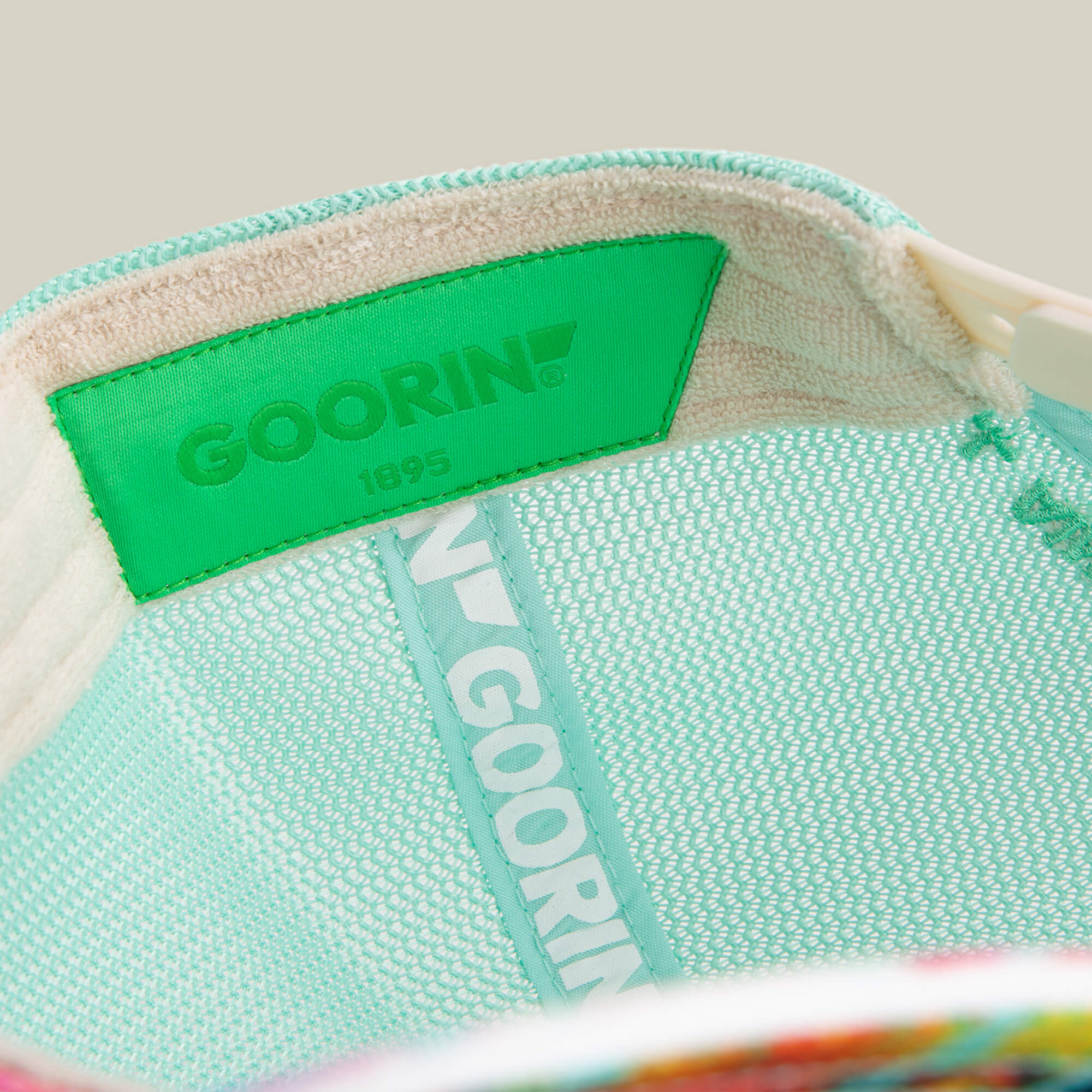 Close-up of the Magic Eye mesh hat by Goorin Bros., highlighting the green brand label and inner lining with the Goorin logo and "1895"—craftsmanship so detailed it nearly creates an optical illusion.