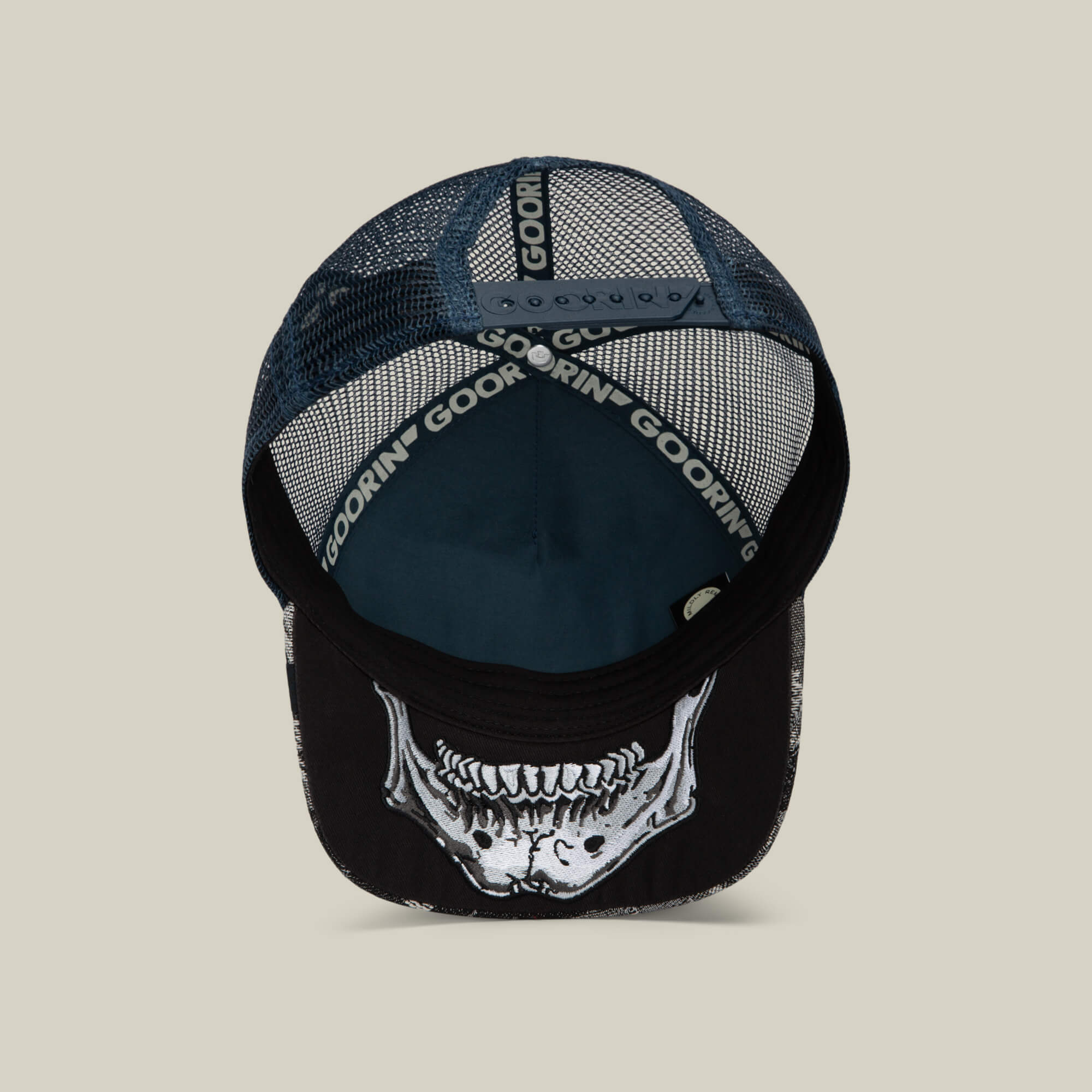 The Bone Head Danger by Goorin Bros. is a black and blue mesh-back hat, seen from above, showcasing a bold skull graphic on the brim and Goorin Bros. branding on the inner band—ideal for fans of classic skull trucker hat style.