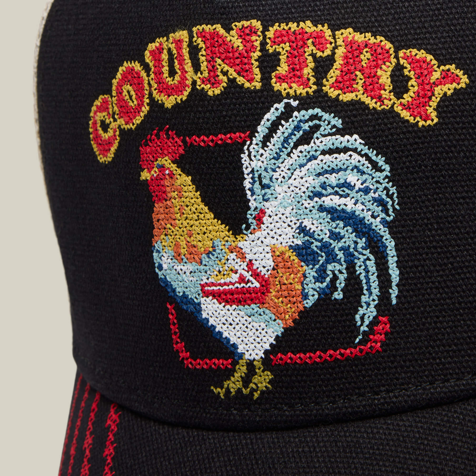 Close-up of the Goorin Bros. "Middle of No Where" black hat with a rooster embroidered inside a red square and COUNTRY stitched above in yellow and red—ideal for fans of home cooking or rural roots.