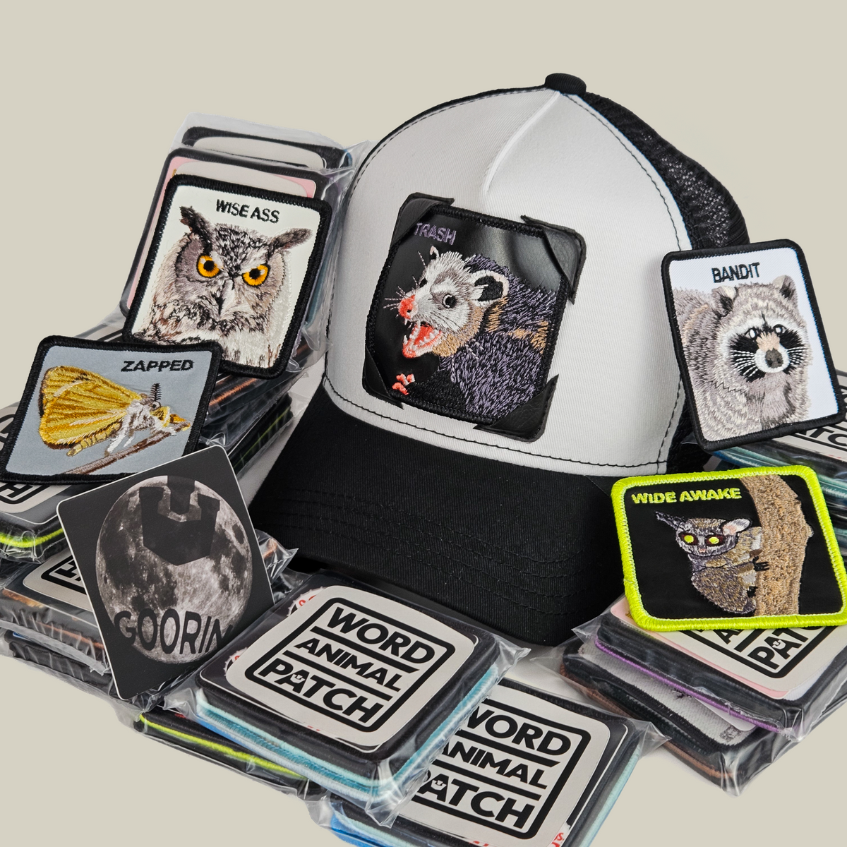 A black and white Nocturnal Patch Pack with GB Patch Corner Trucker hat, featuring a possum patch surrounded by various embroidered animal patches and a moon sticker.