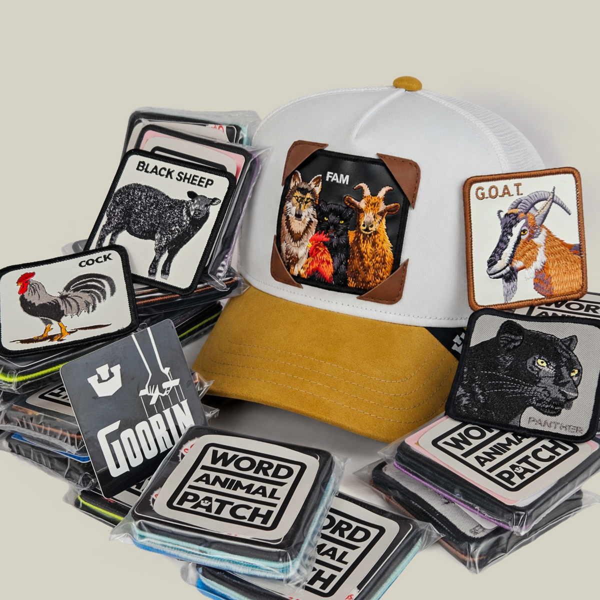 A white and tan Family Patch Pack with GB Patch Corner Trucker - Tan, featuring a farm animal patch on the hat and a stack of additional patches in Patch Corners protective sleeves.