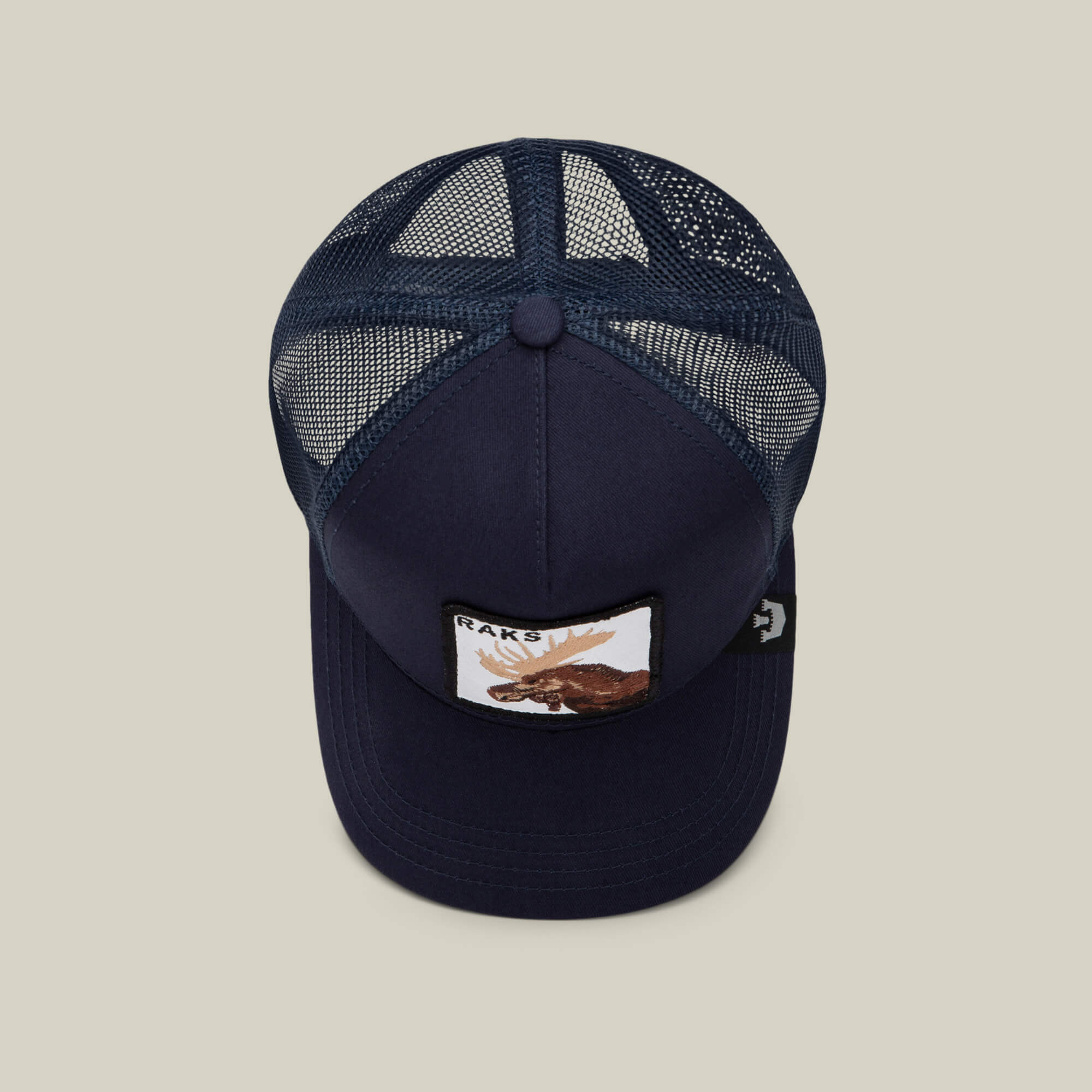 The Goorin Bros. Rakell Moose is a navy blue mesh trucker hat featuring a moose patch with "RACKS" on the front, photographed from above against a plain background—a perfect limited-edition cap for collectors.