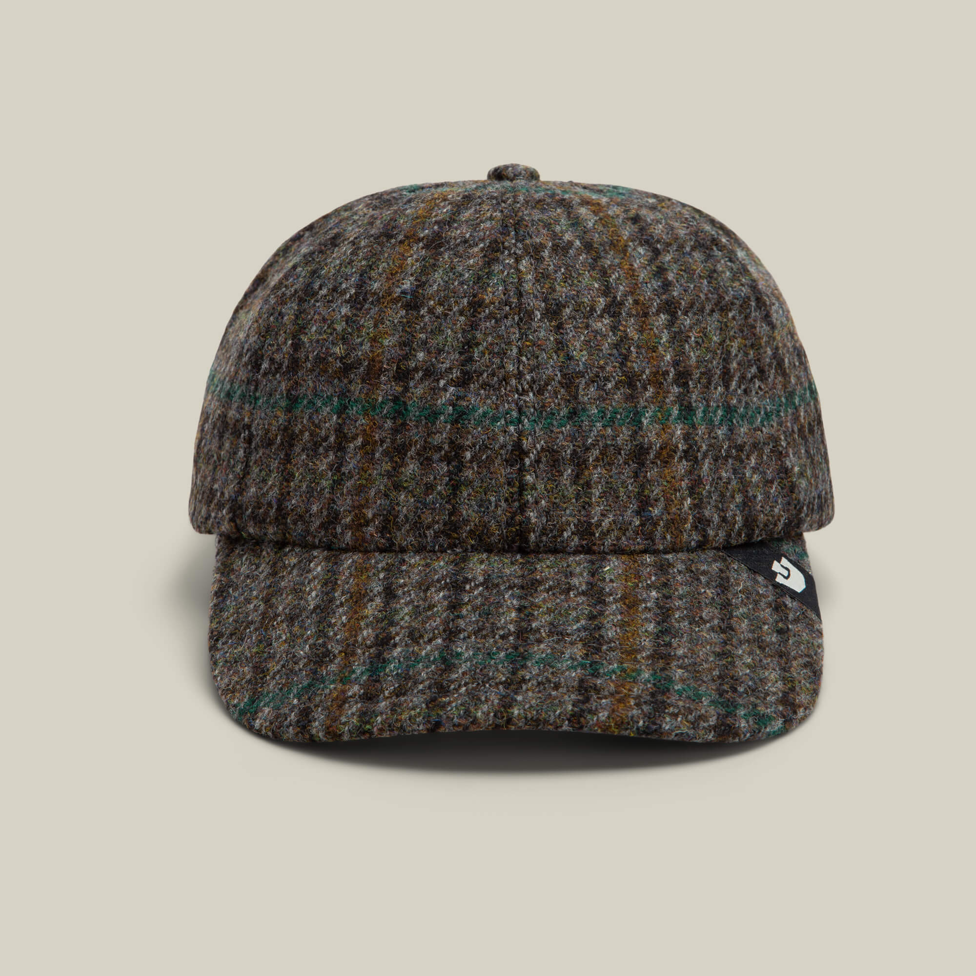 The Goorin Bros. Cozy Tailored Baseball cap in OIL features a muted plaid of brown, green, and gray, shown from the front with a small black tag on the brim.