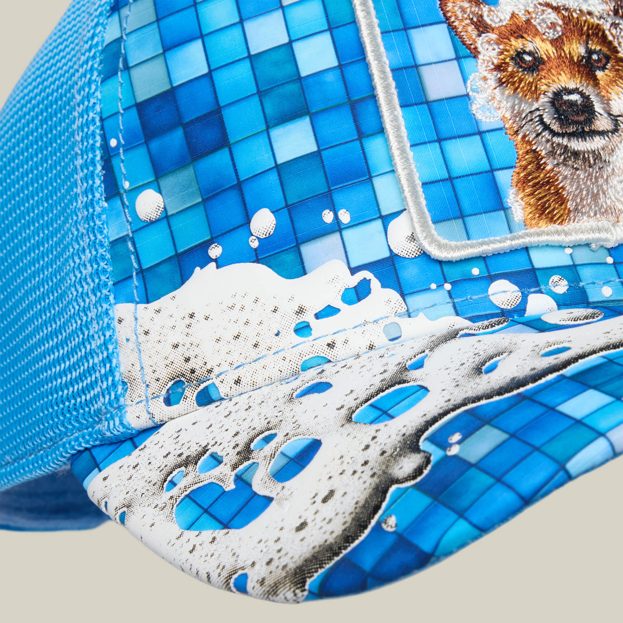 The Squeaky Clean cap by Goorin Bros. features a blue mesh design with a tiled soap suds pattern and partial embroidery of an animal face—possibly a fox—on the front panel, evoking playful bath time vibes.